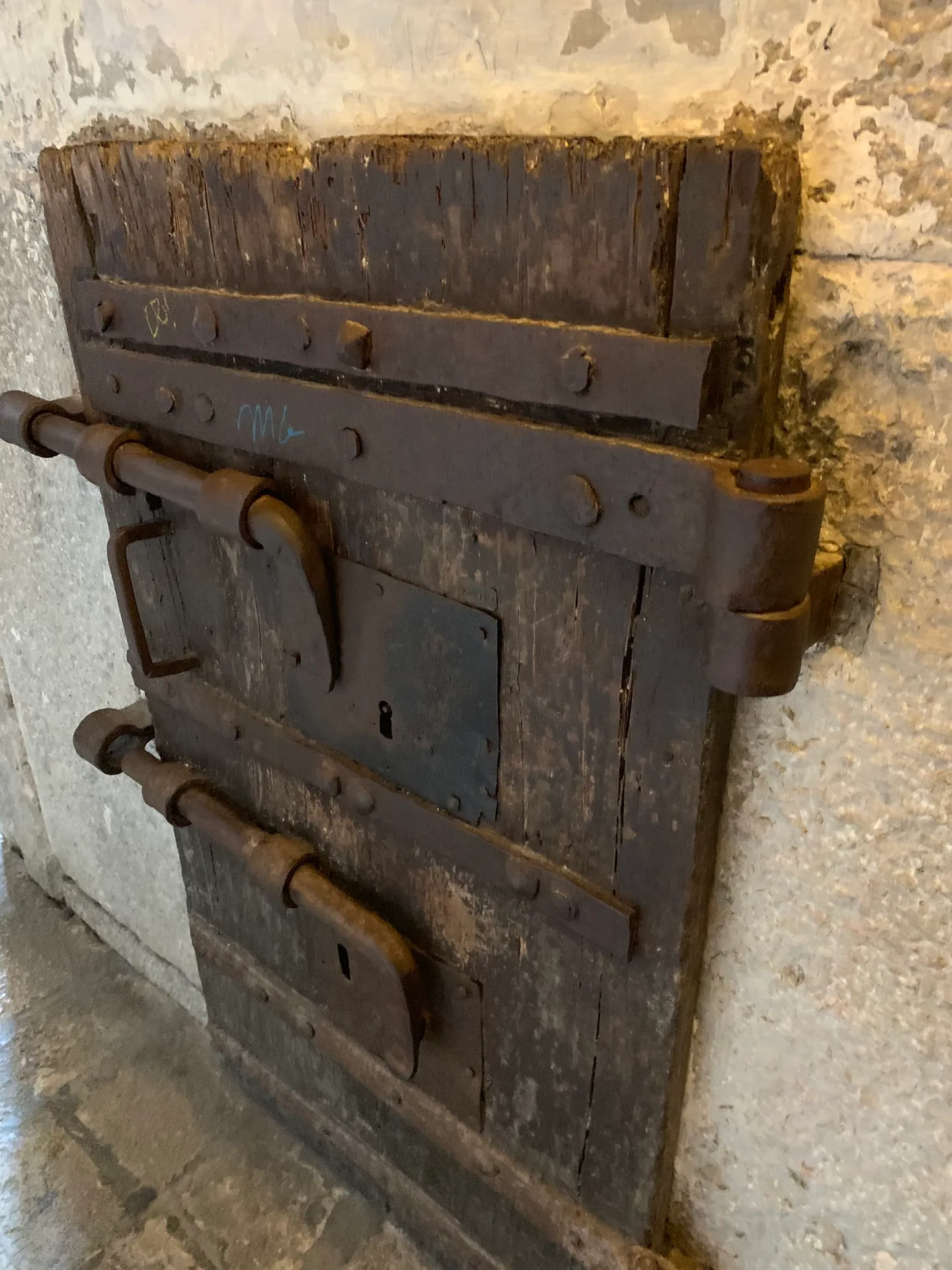 A heavy wooden cell door with iron lock and hinges in the New Prisons of Venice