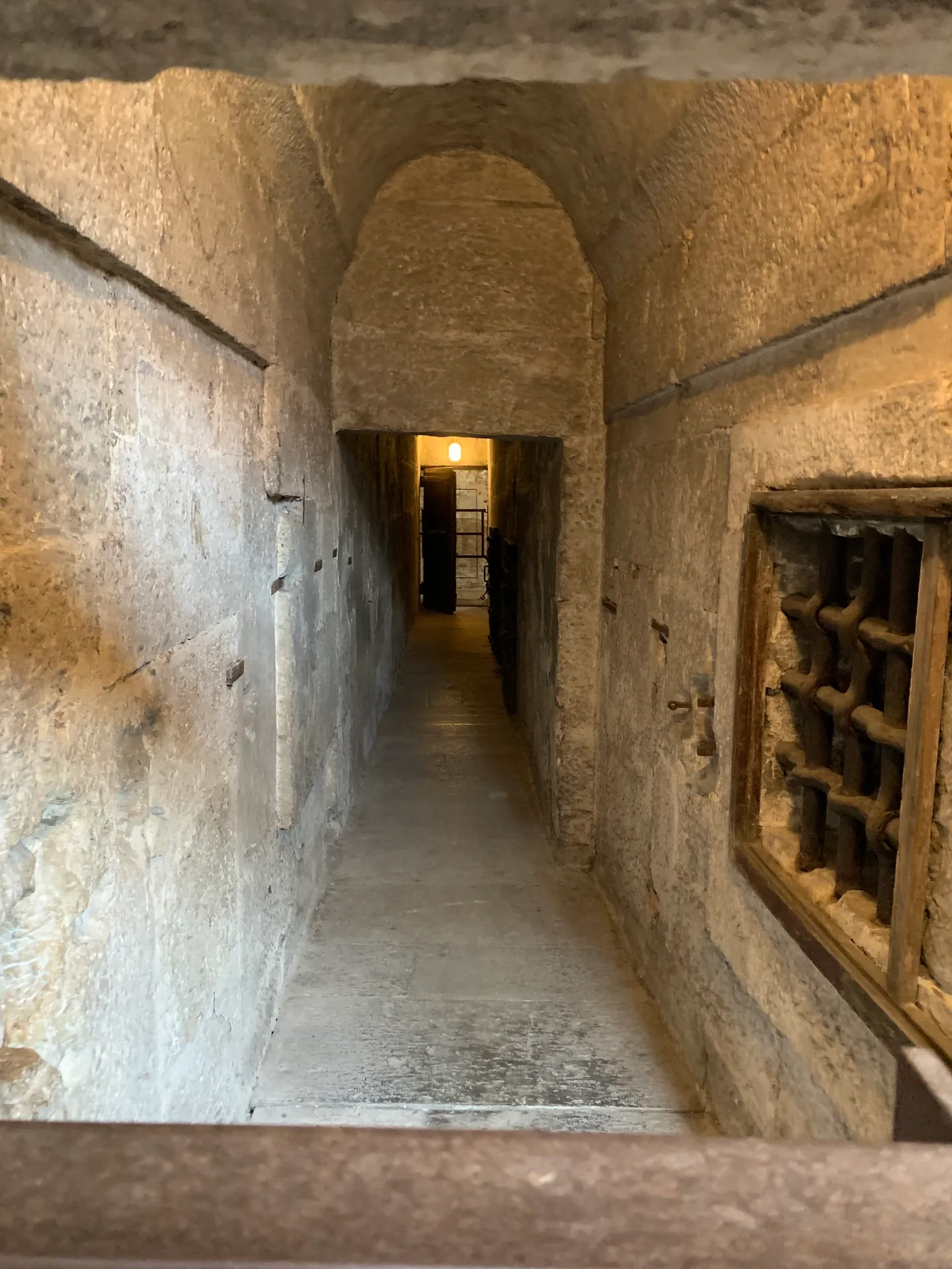 A stone corridor leading to a barred cell in the New Prisons of Venice
