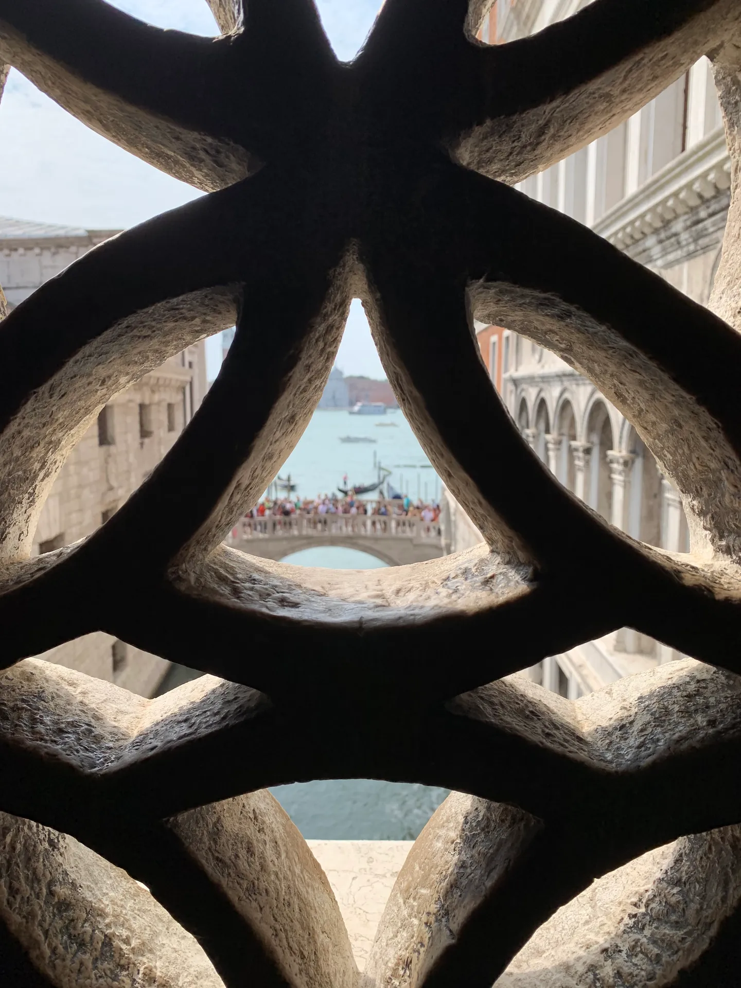 The pierced stone lattice window of the Bridge of Sighs with the lagoon beyond