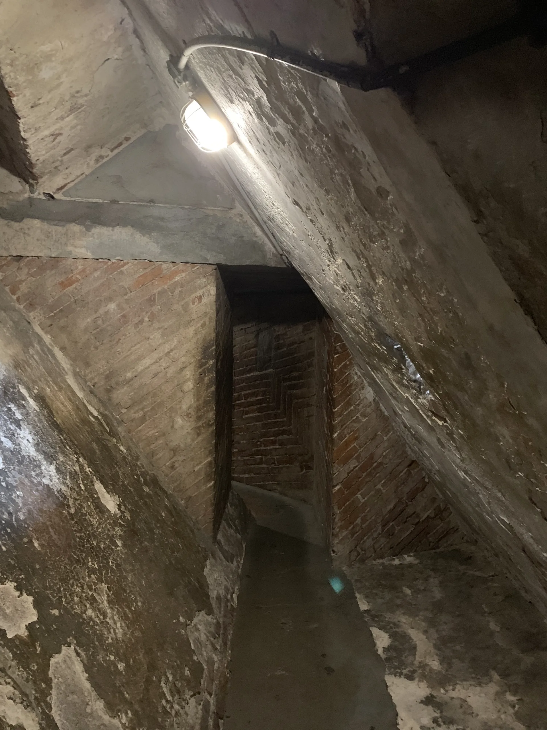 A lit stone and brick passage climbing between the two shells of Brunelleschi's dome