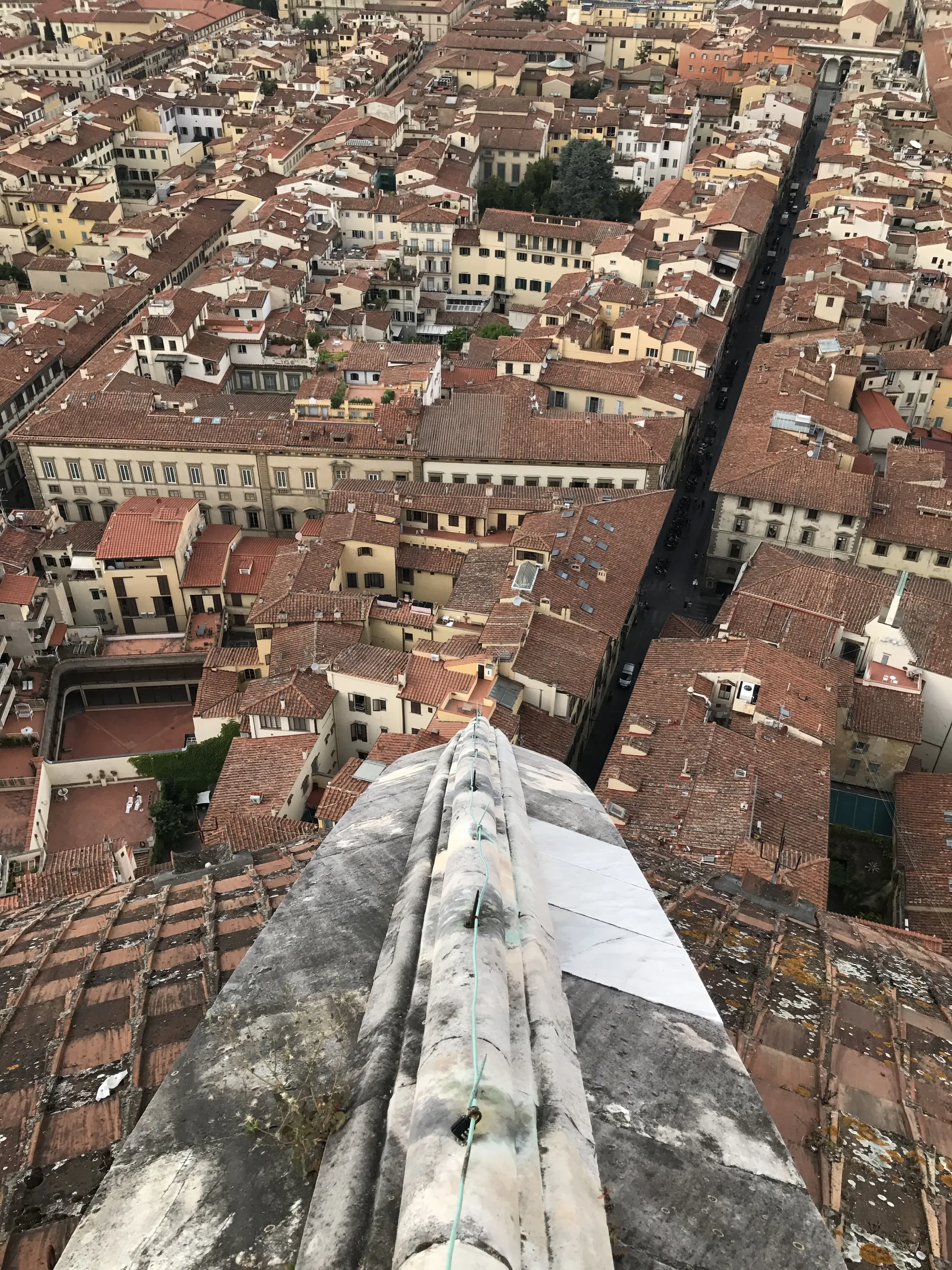 Looking straight down a marble rib of the dome to the street far below