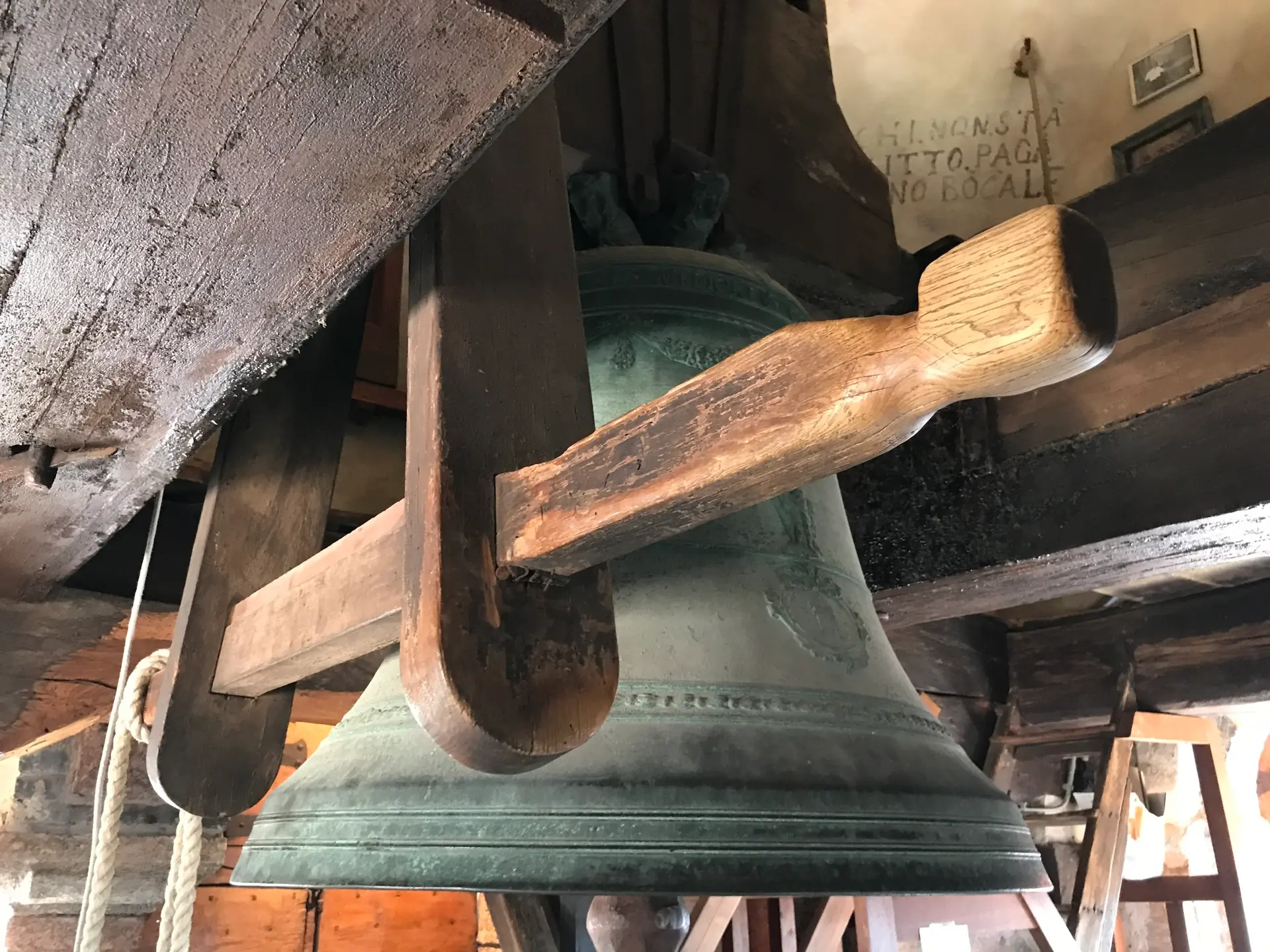 Bronze bell mounted on a heavy wooden headstock beam in the bell chamber.