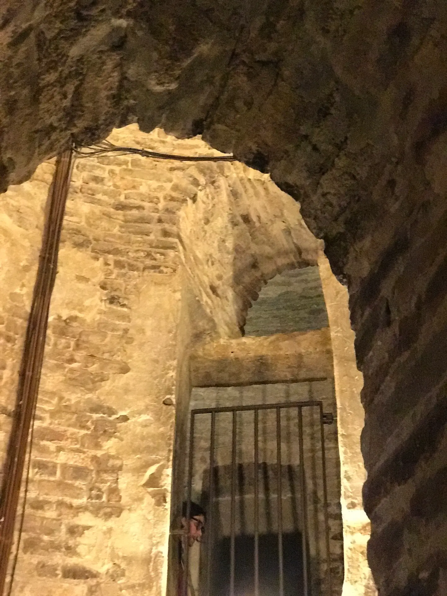 Warm-lit brick archway and worn stone staircase inside the San Pietro bell tower.