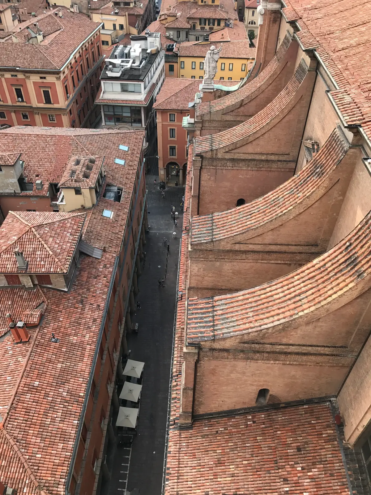 Vertiginous downward view of a Bologna street and rooftops from the bell tower.