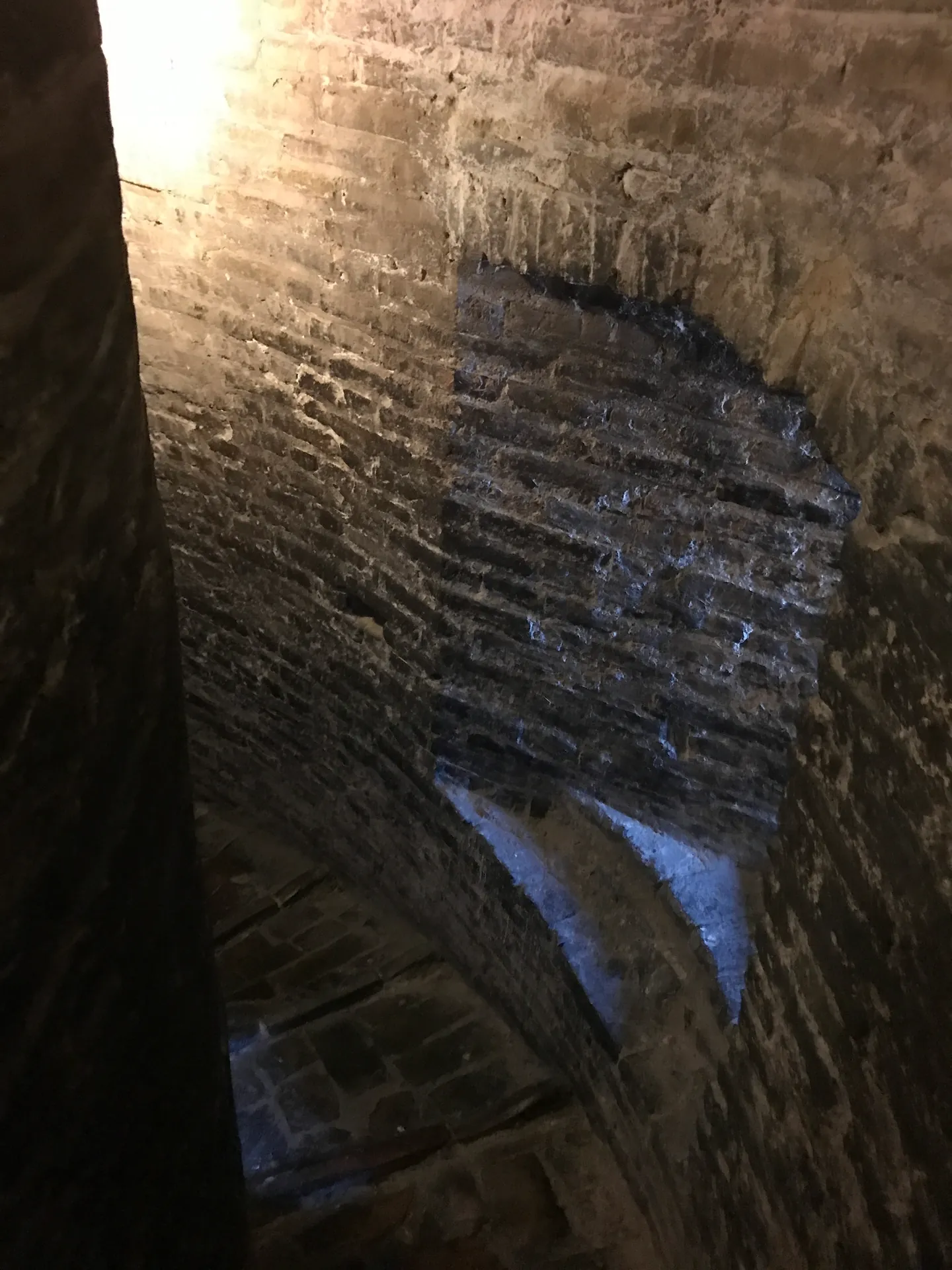 Narrow cylindrical brick shaft of the encased 10th-century tower lit from above.