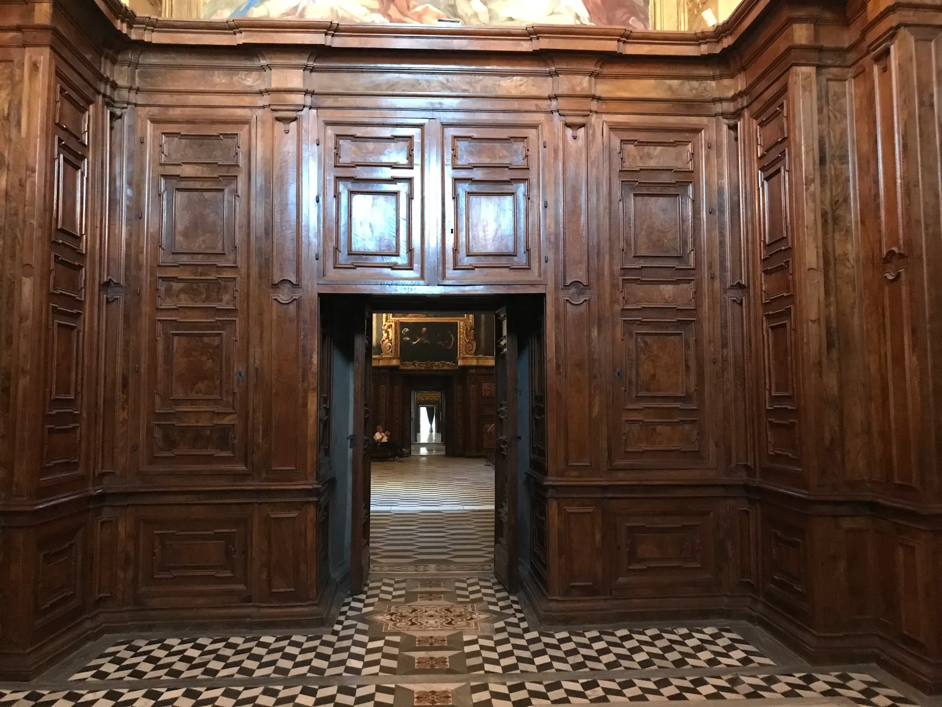 Inlaid wooden doors and a chequerboard marble floor in a Naples interior
