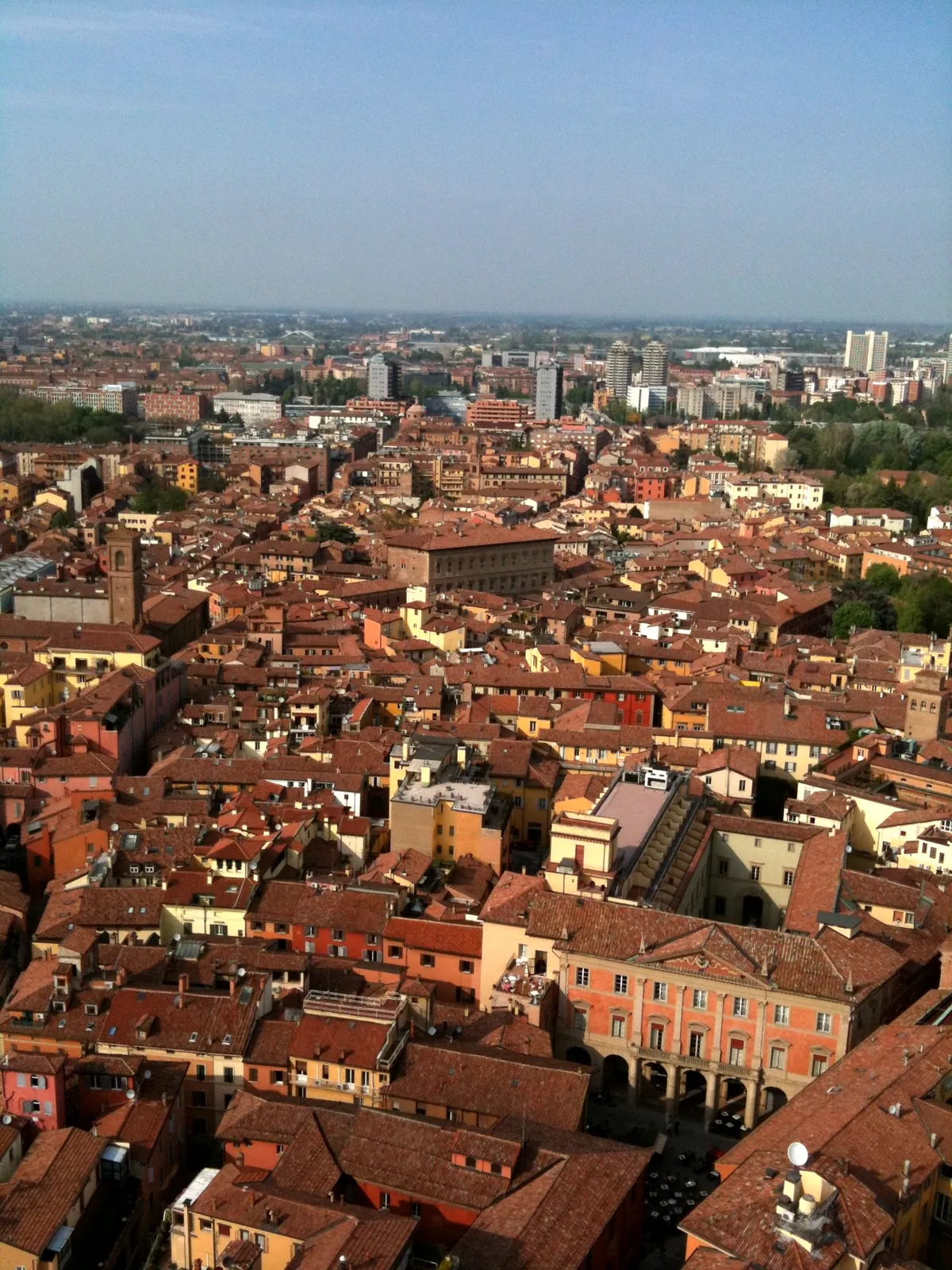 Wide panorama of Bologna's rooftops and distant hills from the Asinelli tower.