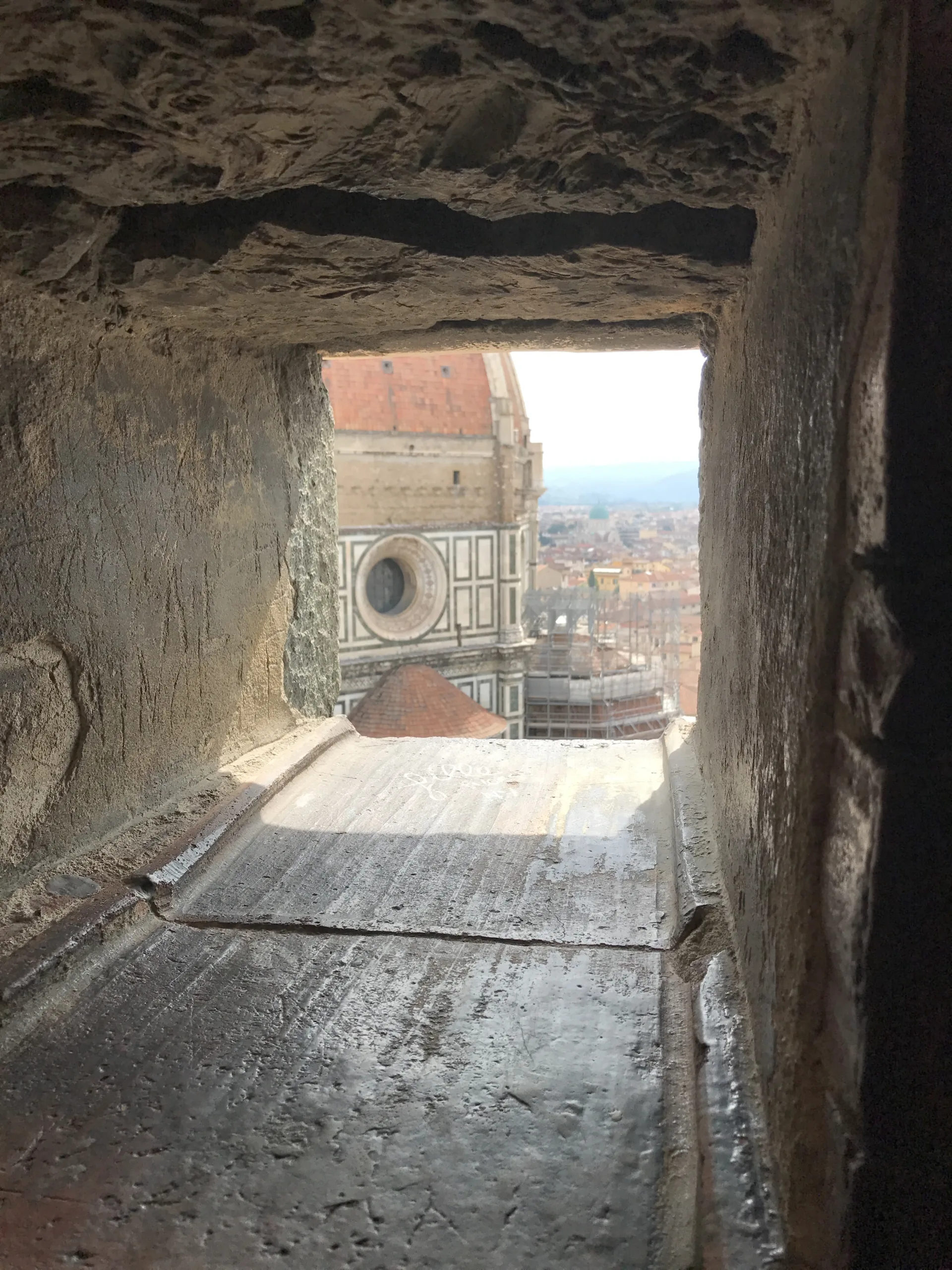 Brunelleschi's dome framed in a stone loophole on the campanile stair