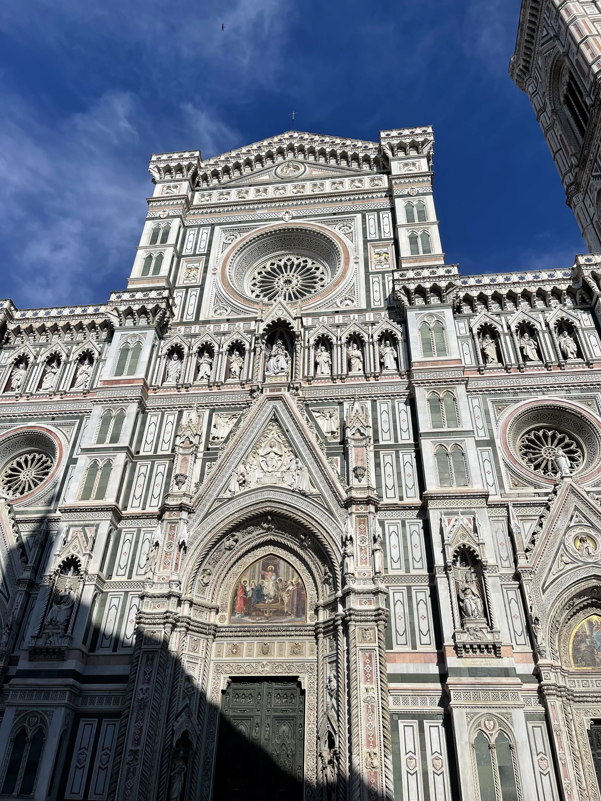 The polychrome marble facade of Florence Cathedral in raking morning light