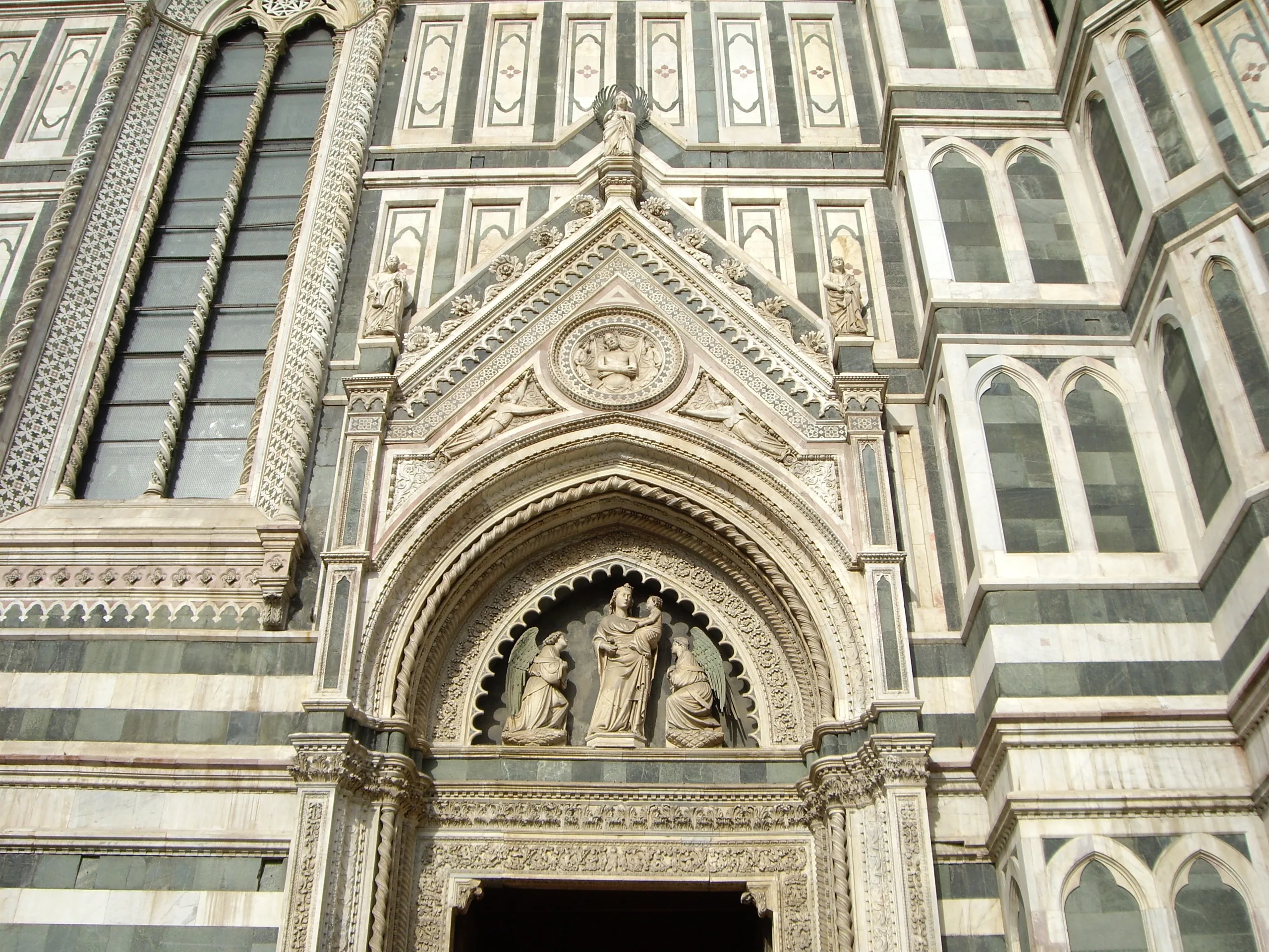 A side portal of the cathedral facade with its carved tympanum and marble inlay