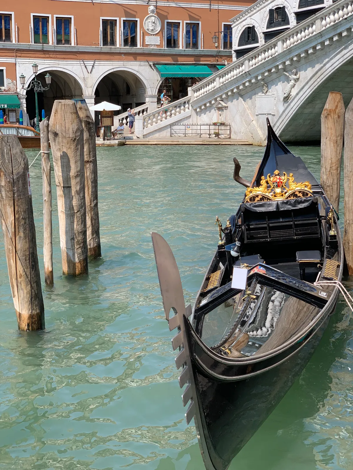 The black hull and curved prow of a moored gondola on the Grand Canal