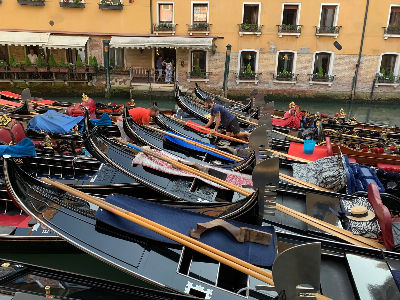 Rows of gondolas moored close together at a Venice basin