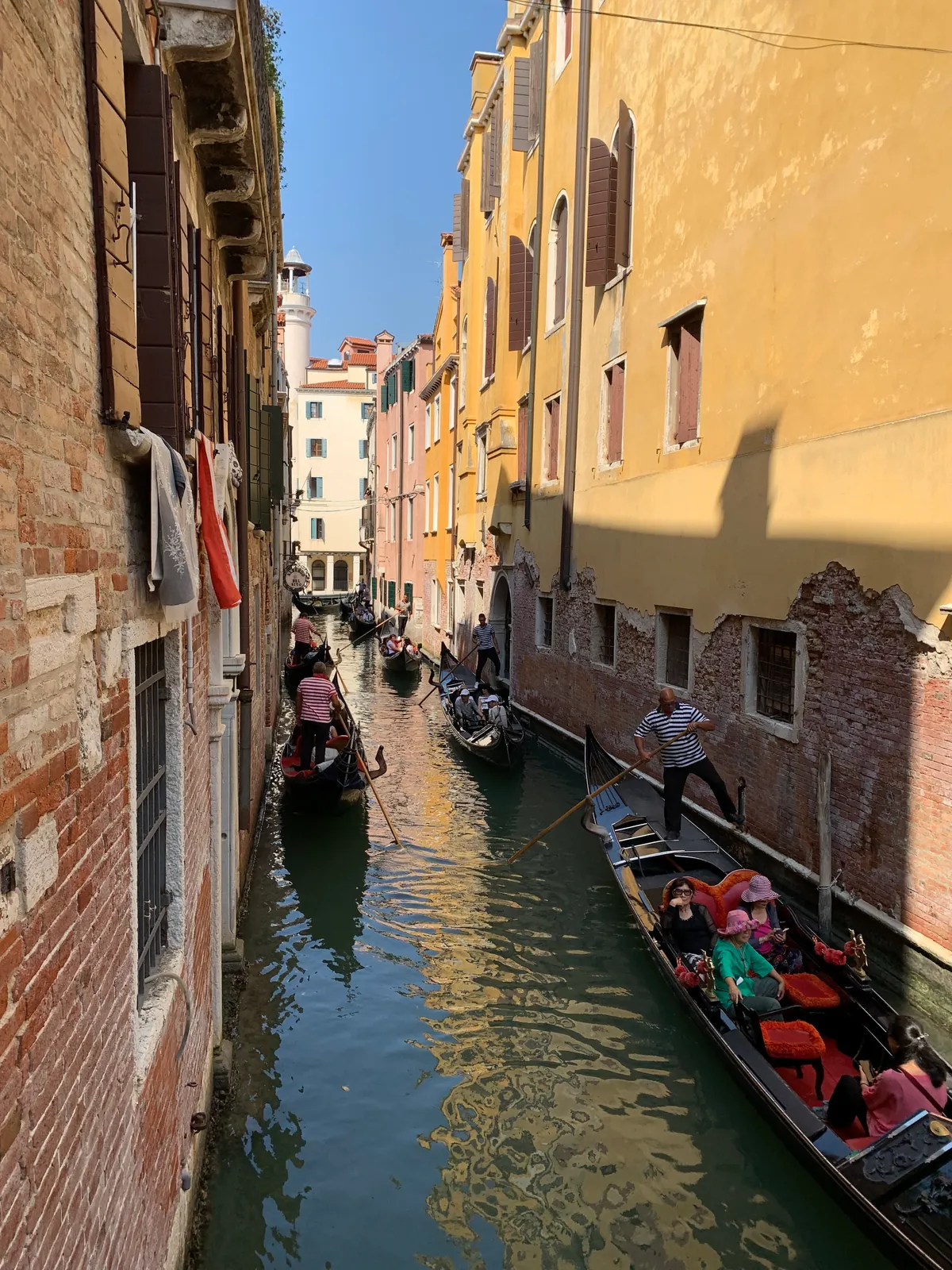 A gondola poled along a narrow canal between old Venetian houses