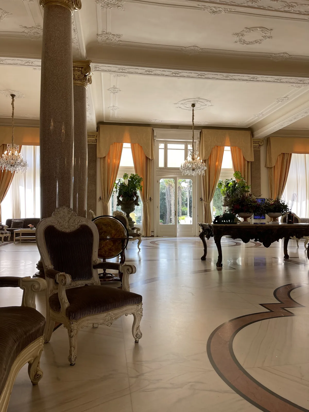 Columned salon with chandeliers inside the Grand Hotel Rimini