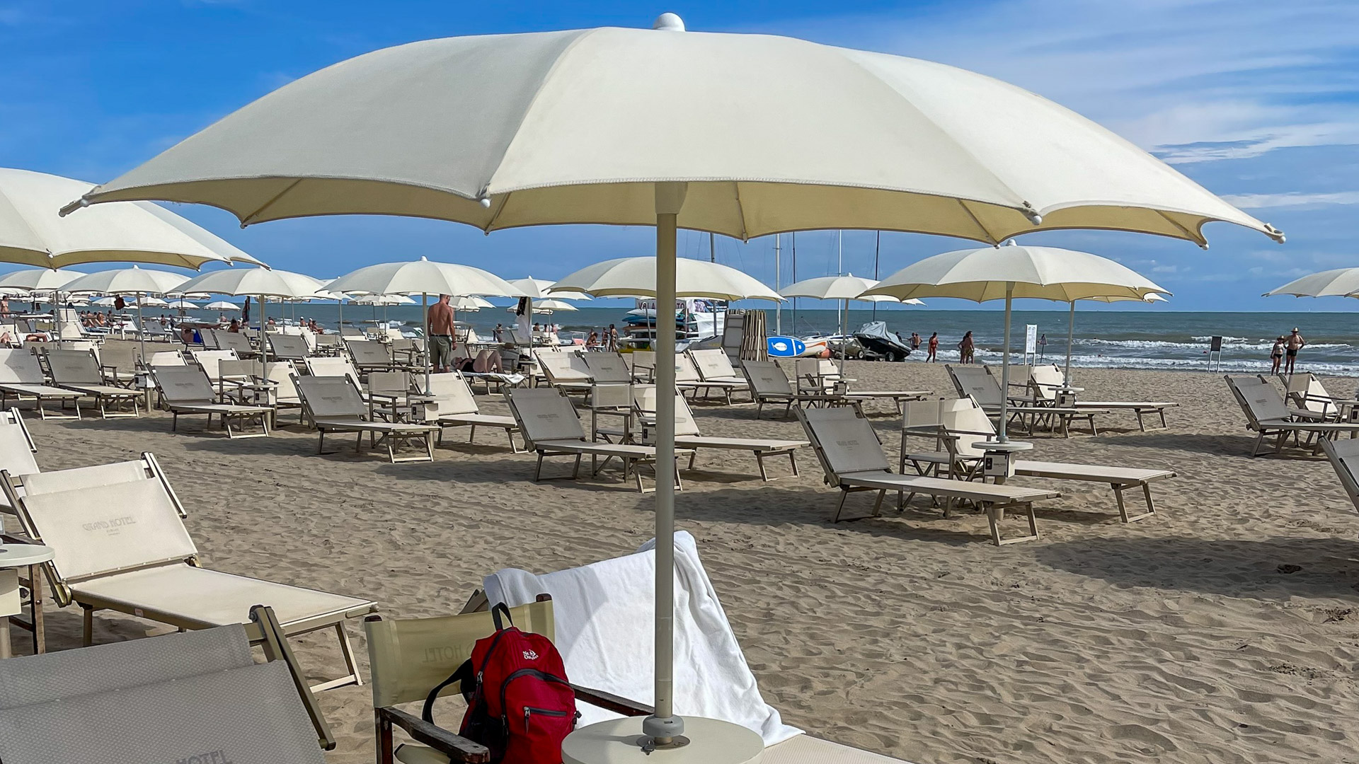 A single dressed beach umbrella and lounger on the Grand Hotel Rimini private beach