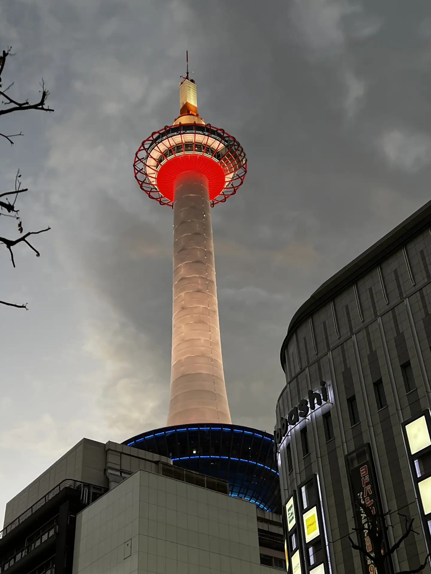 Kyoto Tower lit against a grey winter sky above the station district