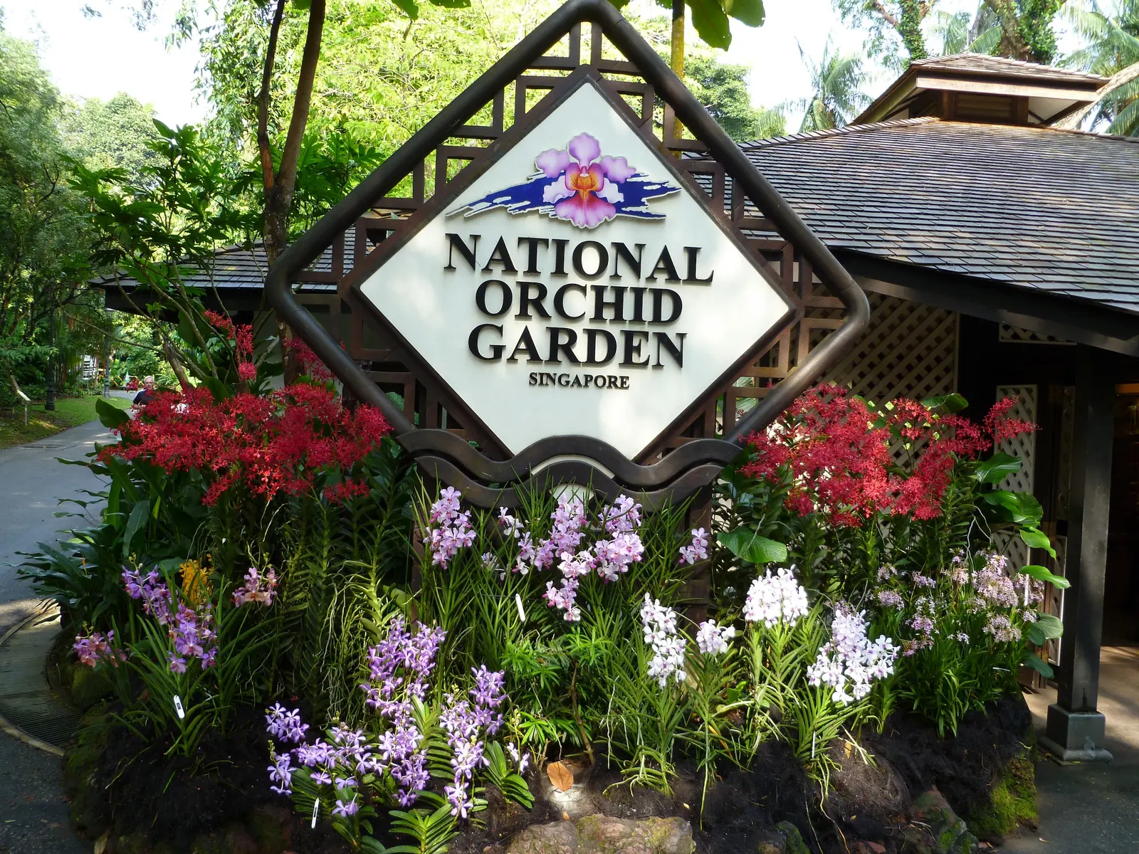 The National Orchid Garden entrance sign banked with orchids and flowers in Singapore