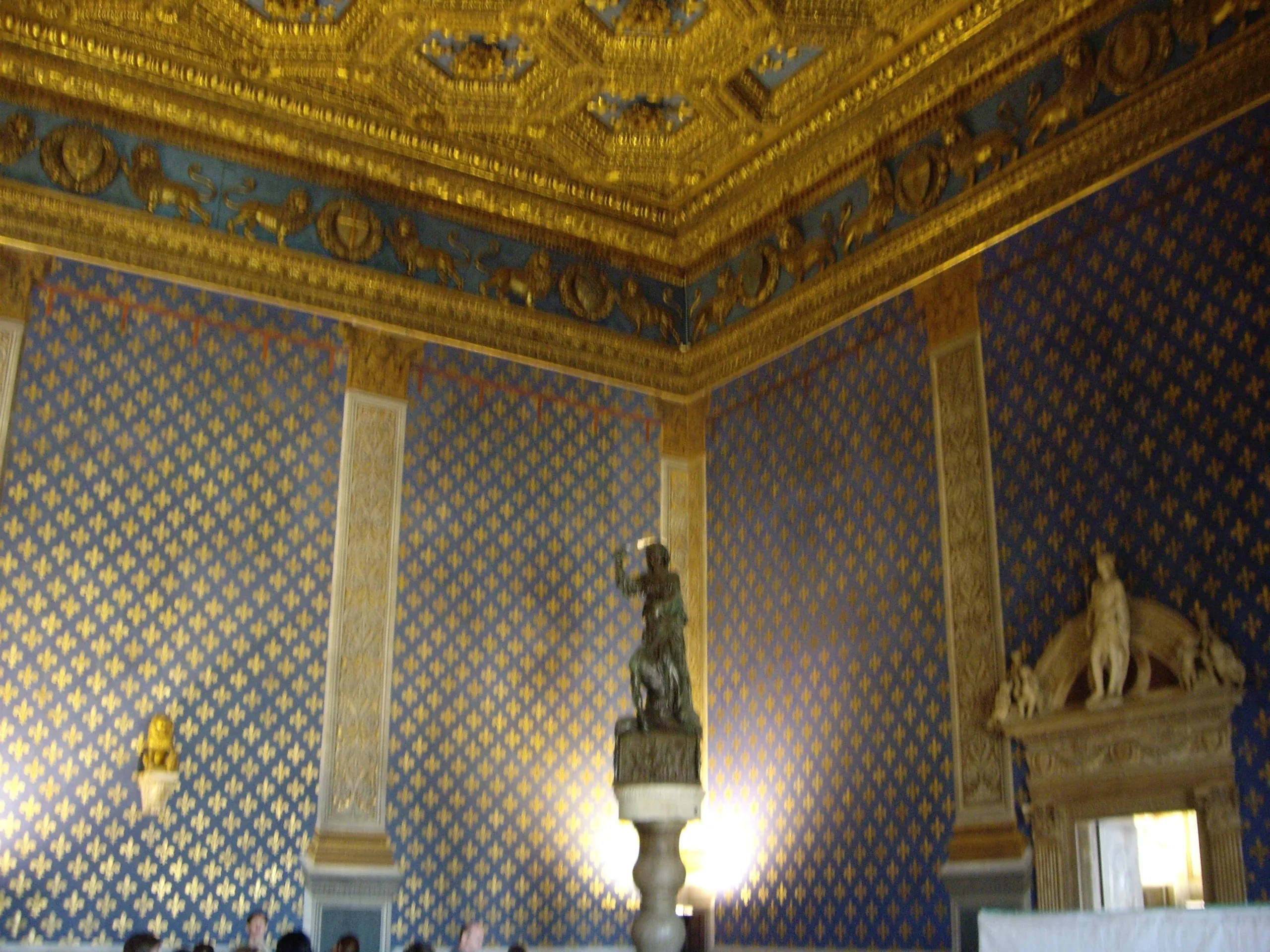 The Sala dei Gigli in the Palazzo Vecchio, its walls patterned with gold lilies under a gilded ceiling