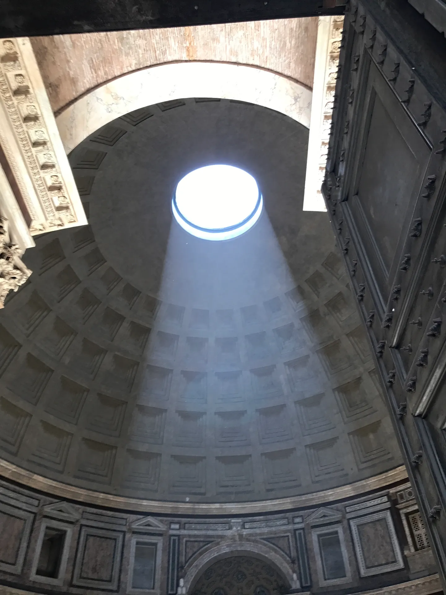 Sunbeam from the oculus lighting the Pantheon dome, seen from near the entrance