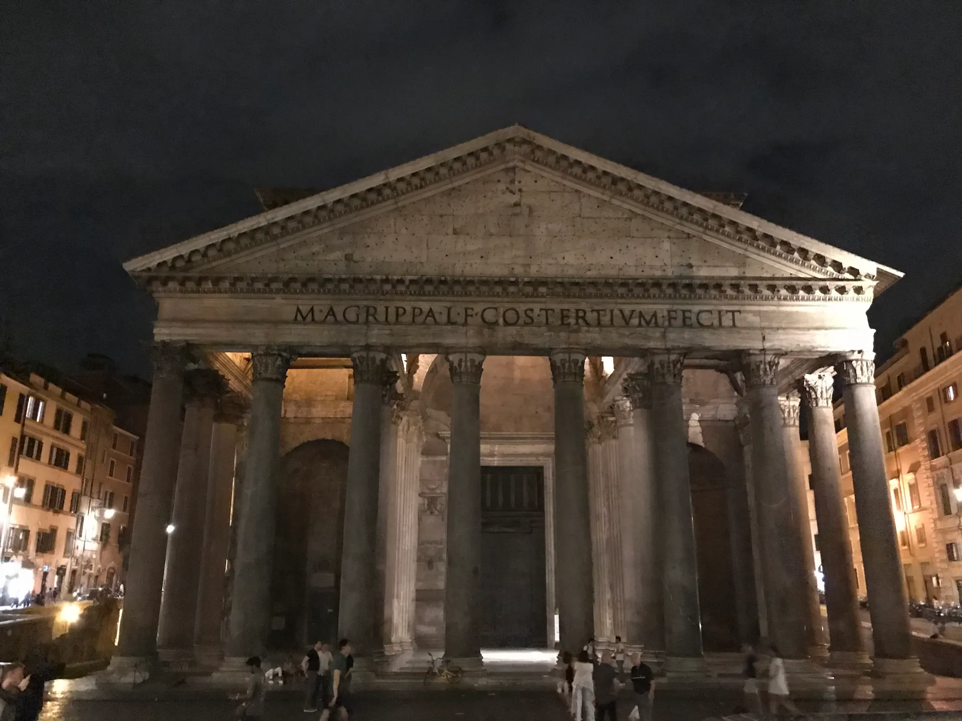 The Pantheon facade illuminated at night with an almost empty piazza