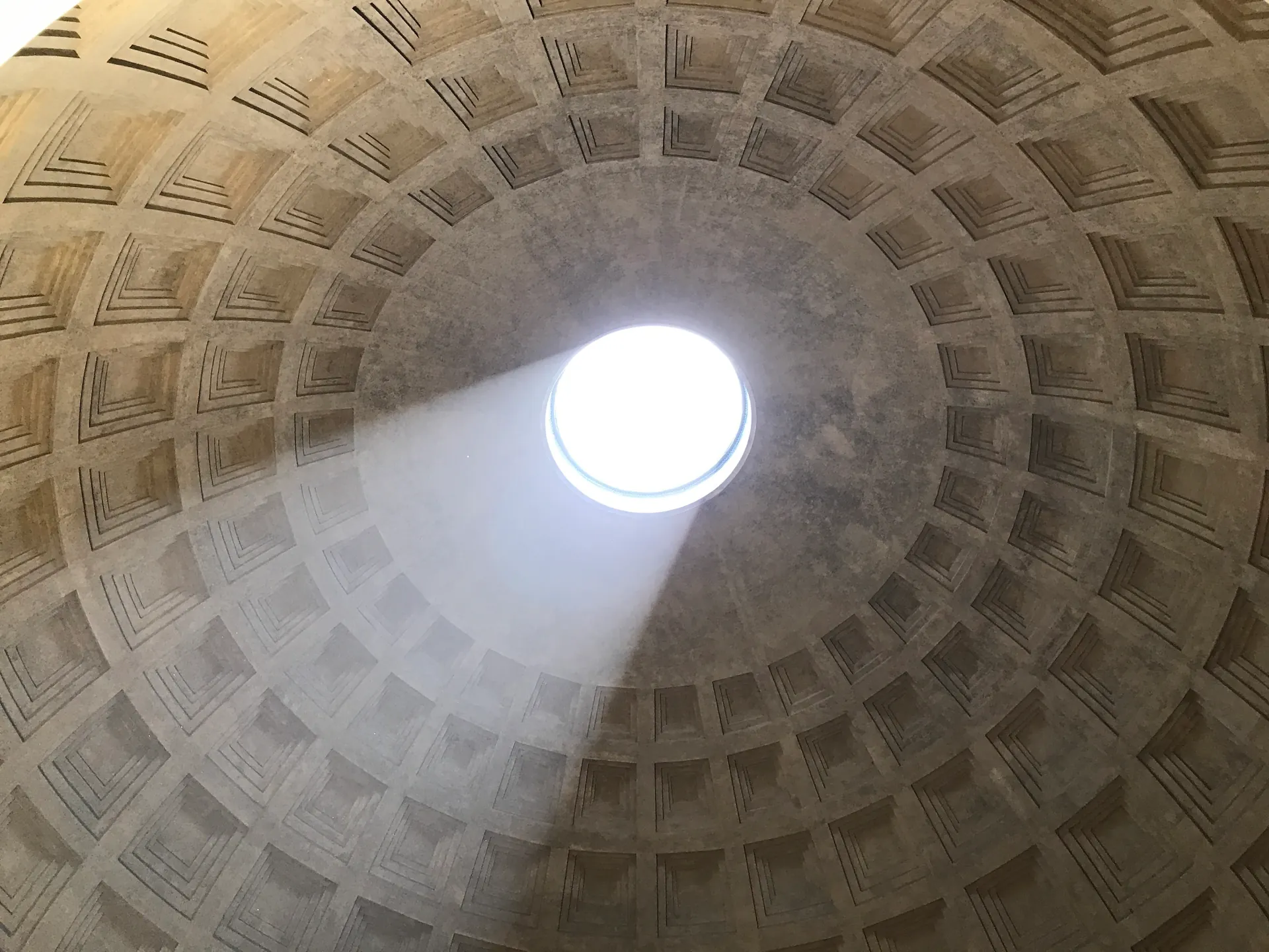 Beam of sunlight streaming through the Pantheon oculus across the coffered dome
