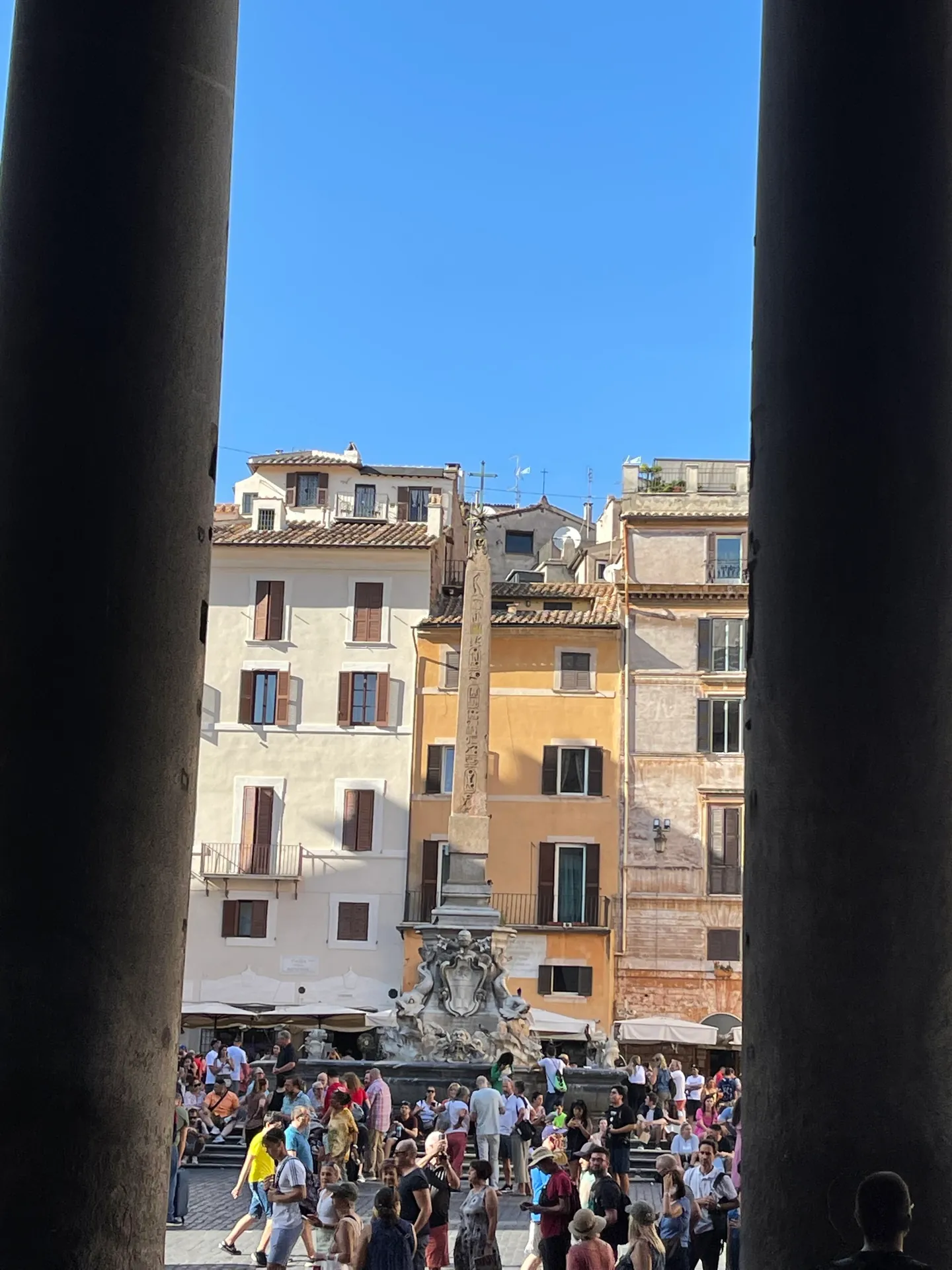 Piazza della Rotonda framed between two dark granite columns of the Pantheon portico
