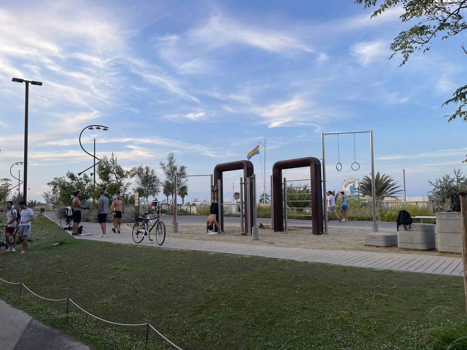 Rusted arch sculptures and exercise rings on a lawn at the Parco del Mare Rimini