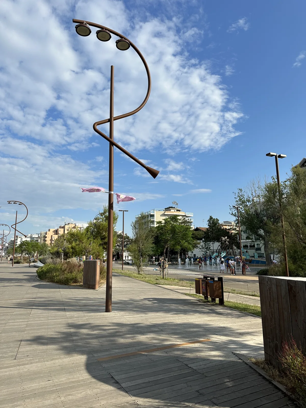 A curved sculptural lamppost against the sky on Rimini's seafront promenade