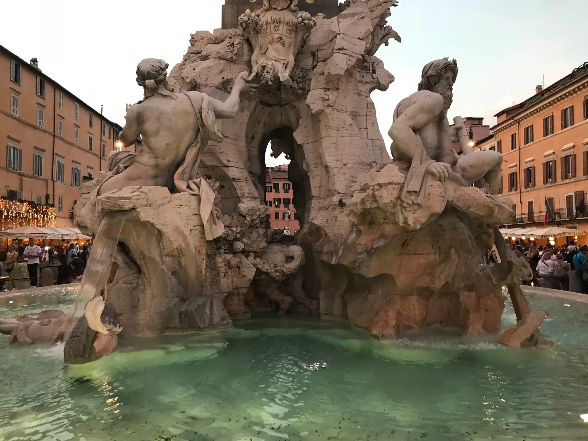 Four Rivers fountain grotto at dusk with underwater lights glowing in the basin