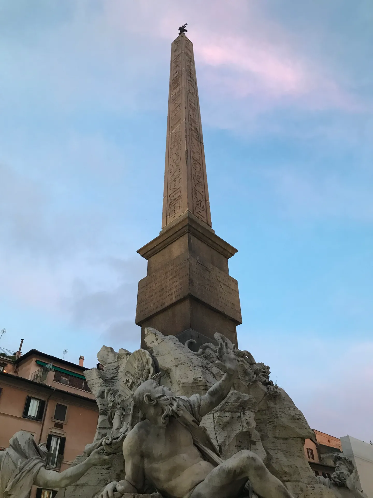 Obelisk of Domitian silhouetted against a pink and blue dusk sky