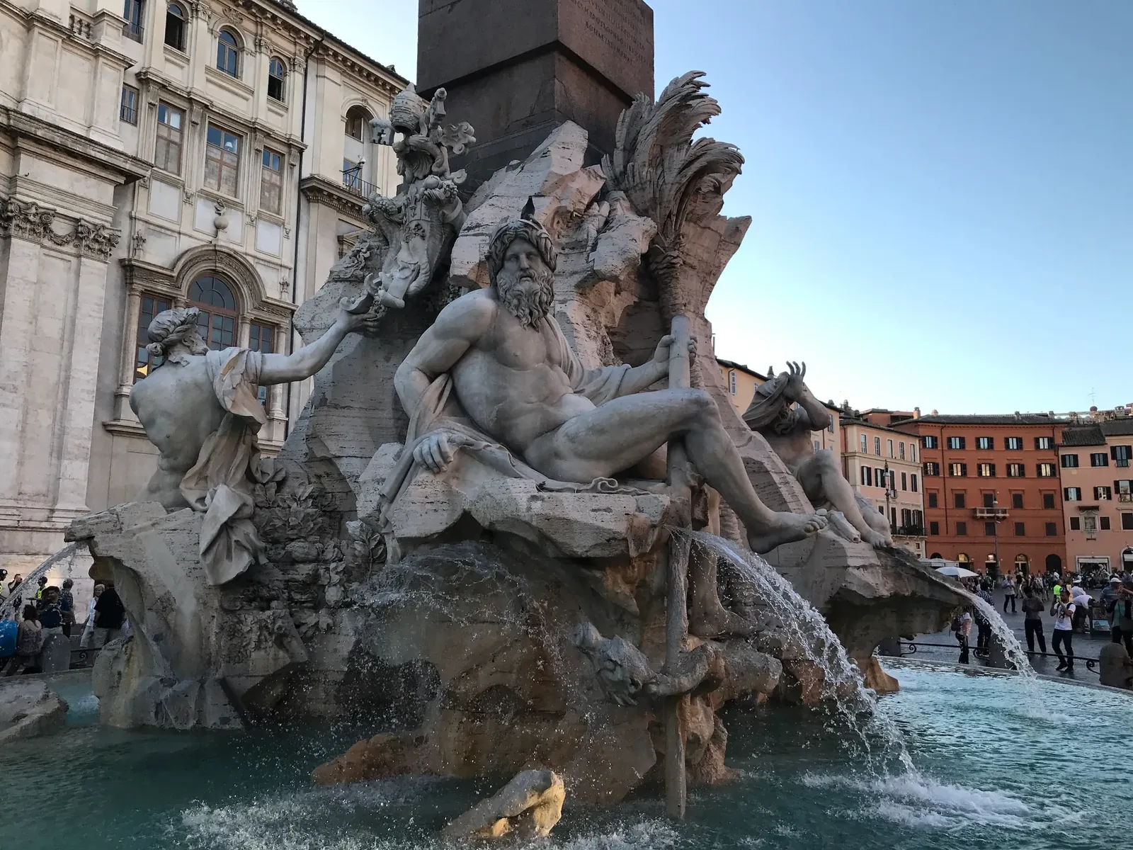 Ganges river god statue with oar in golden evening light at Piazza Navona