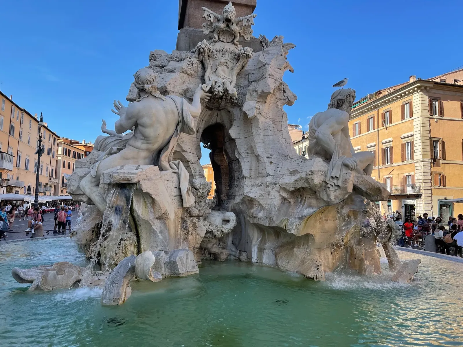 Pierced travertine grotto of the Four Rivers fountain with birds perched on the carved rock