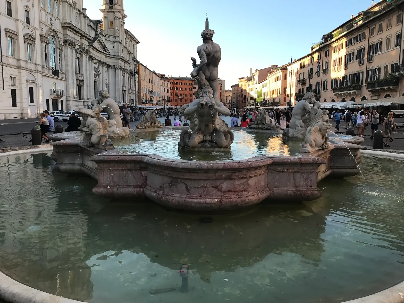 Triton figures of the Fontana del Moro in warm evening light