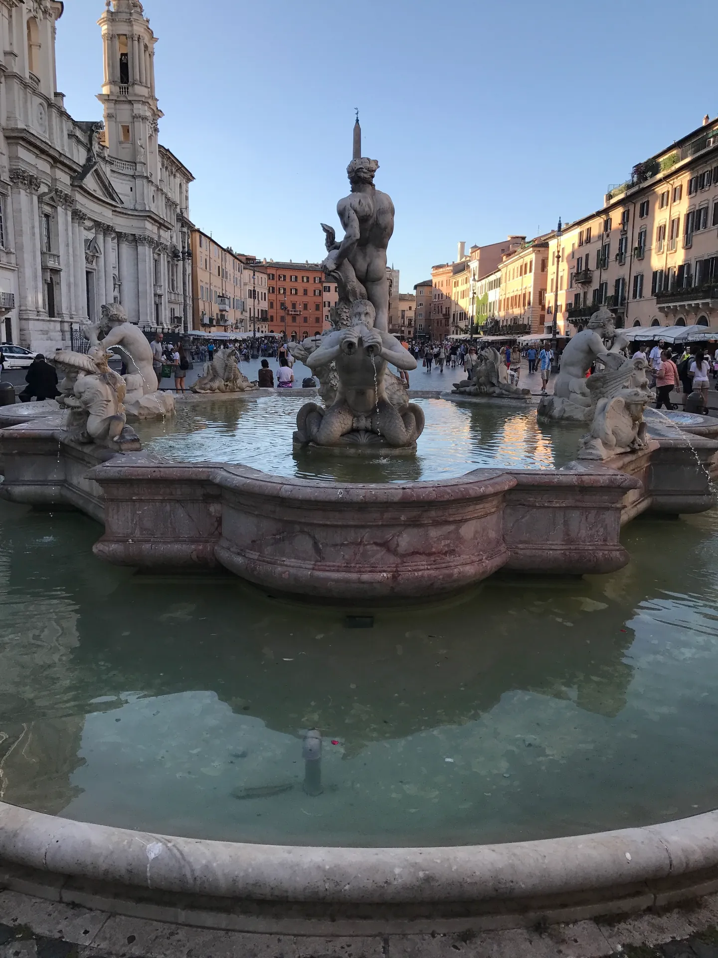 Fontana del Moro at Piazza Navona's south end with Sant'Agnese in the background at golden hour