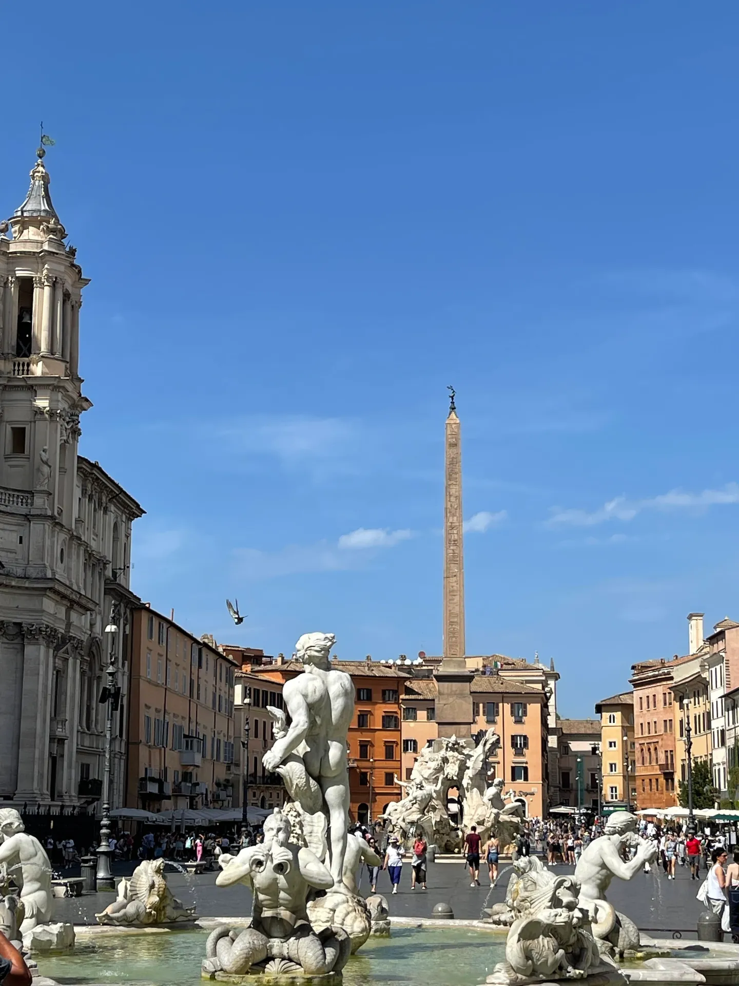 Fontana del Moro statues with the obelisk of the Four Rivers fountain rising behind