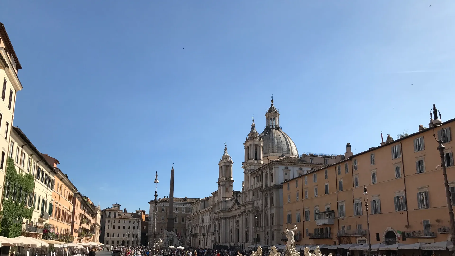 View south across Piazza Navona from the north end with the Neptune fountain, obelisk and Sant'Agnese dome