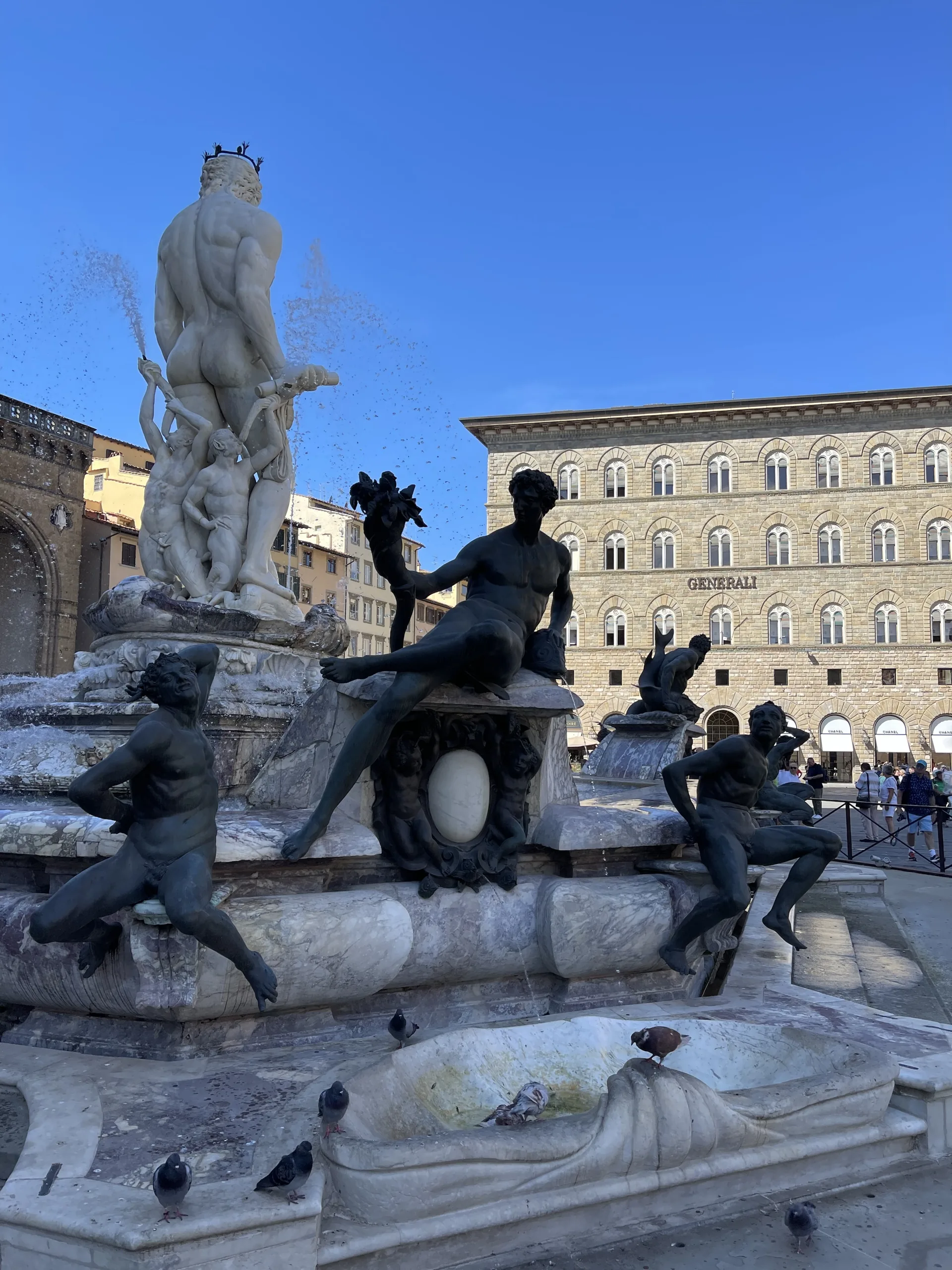 Bronze sea creatures and attendant figures around the rim of the Neptune fountain