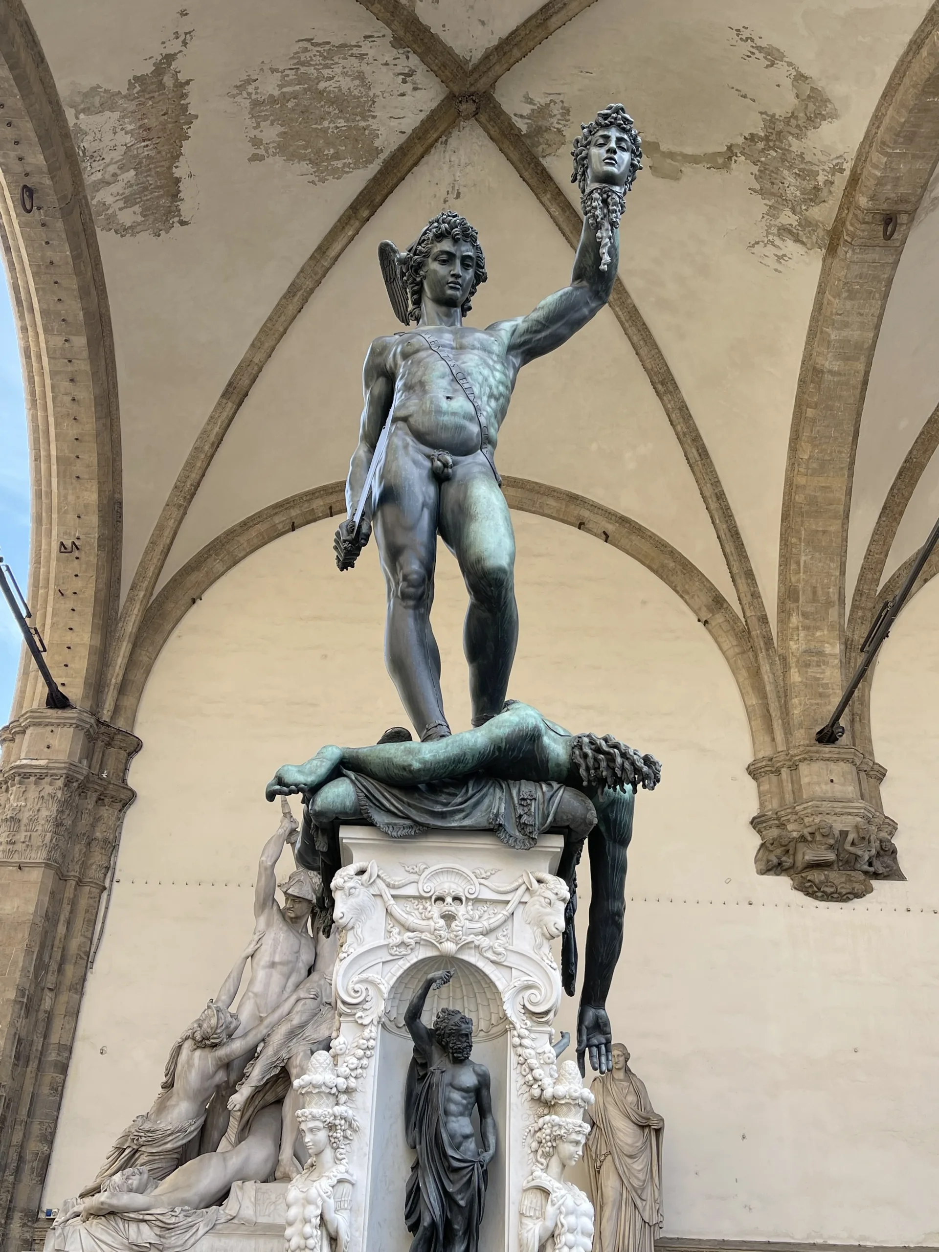 Cellini's bronze Perseus holding the head of Medusa aloft under the vaults of the Loggia dei Lanzi