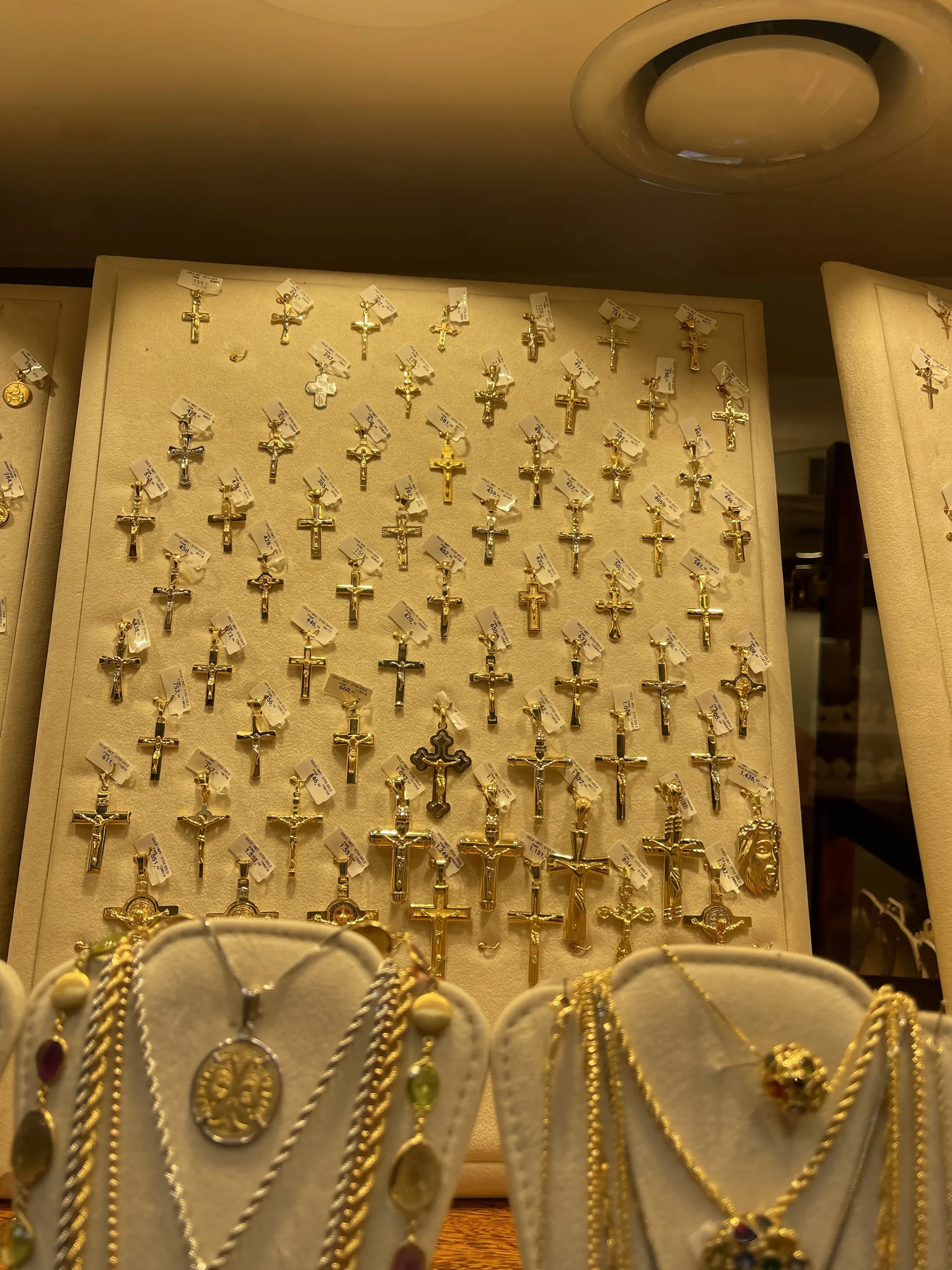 A display wall of gold crosses and pendants in a Ponte Vecchio goldsmith's shop