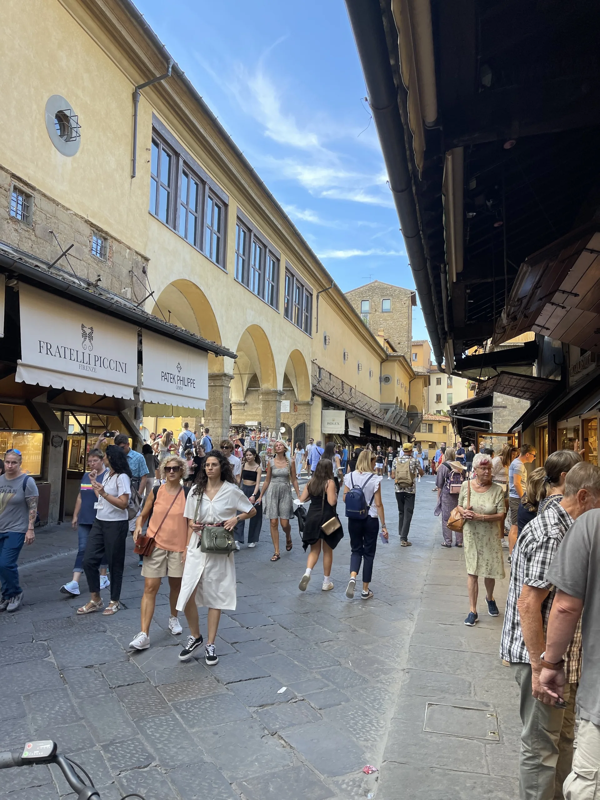 Shopfronts pressing in on both sides of the Ponte Vecchio walkway