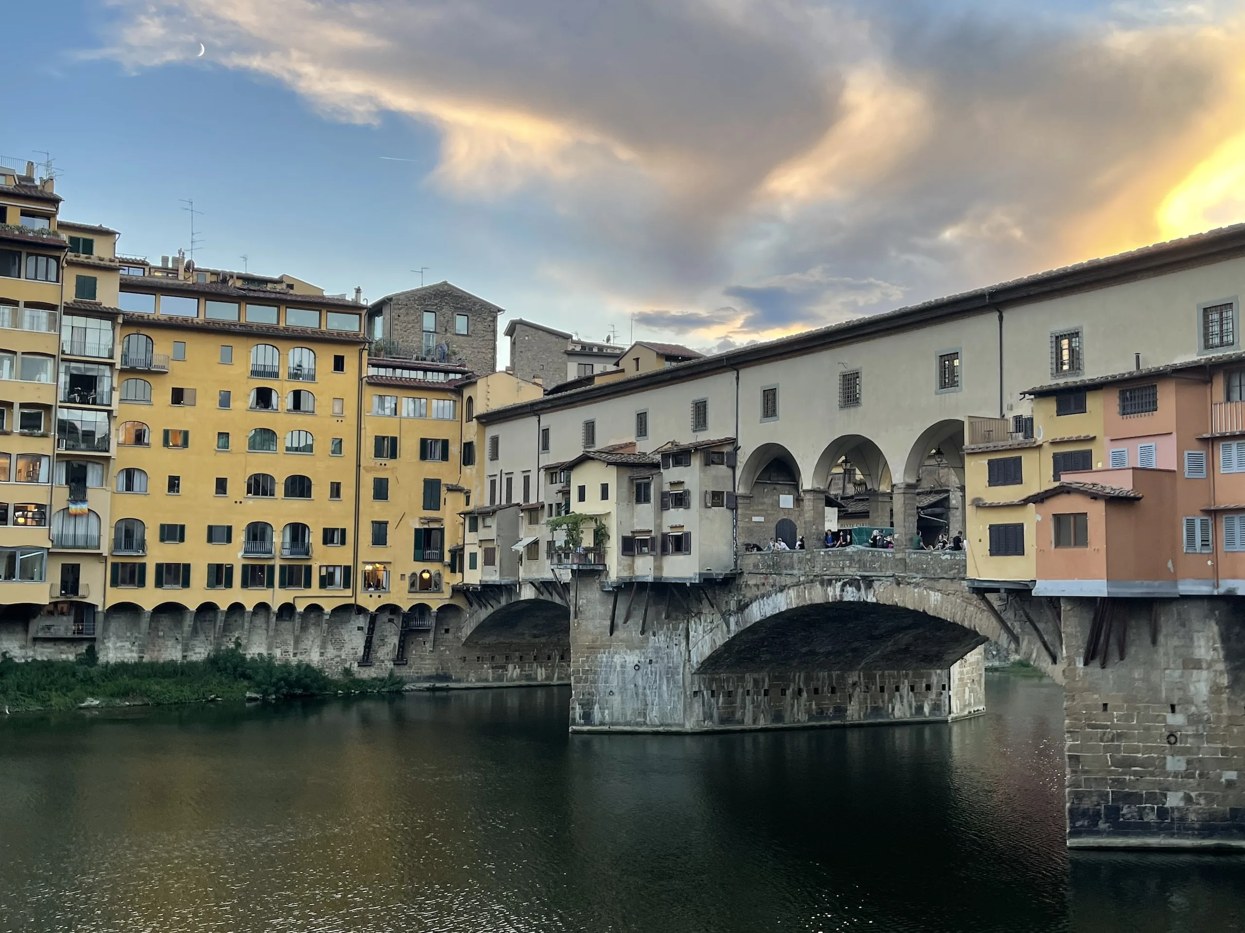 The Ponte Vecchio in late evening light, the shops warm above the Arno
