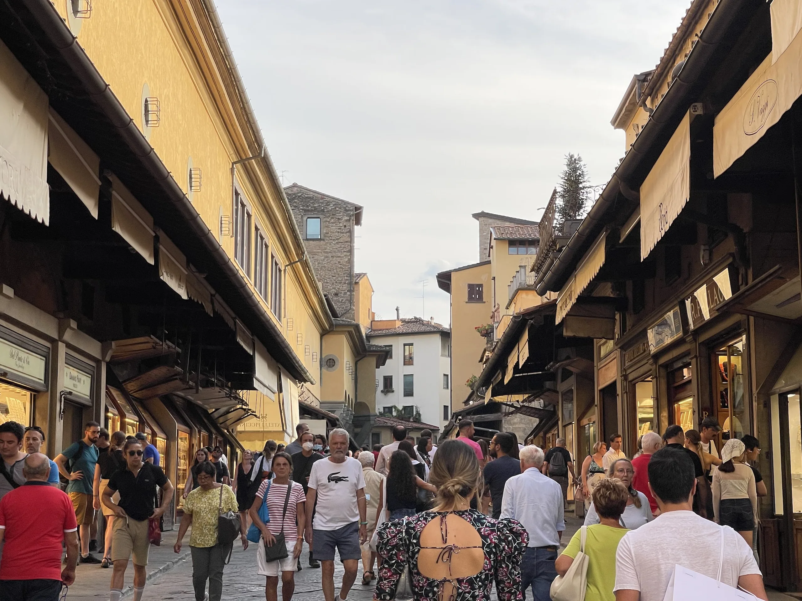 Visitors crossing the Ponte Vecchio shoulder to shoulder in the evening