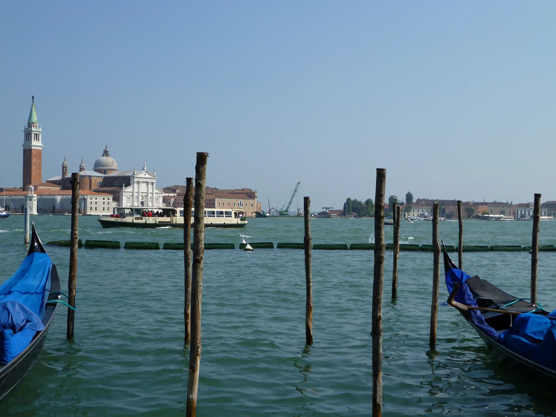 San Giorgio Maggiore across the lagoon with gondola prows and mooring poles