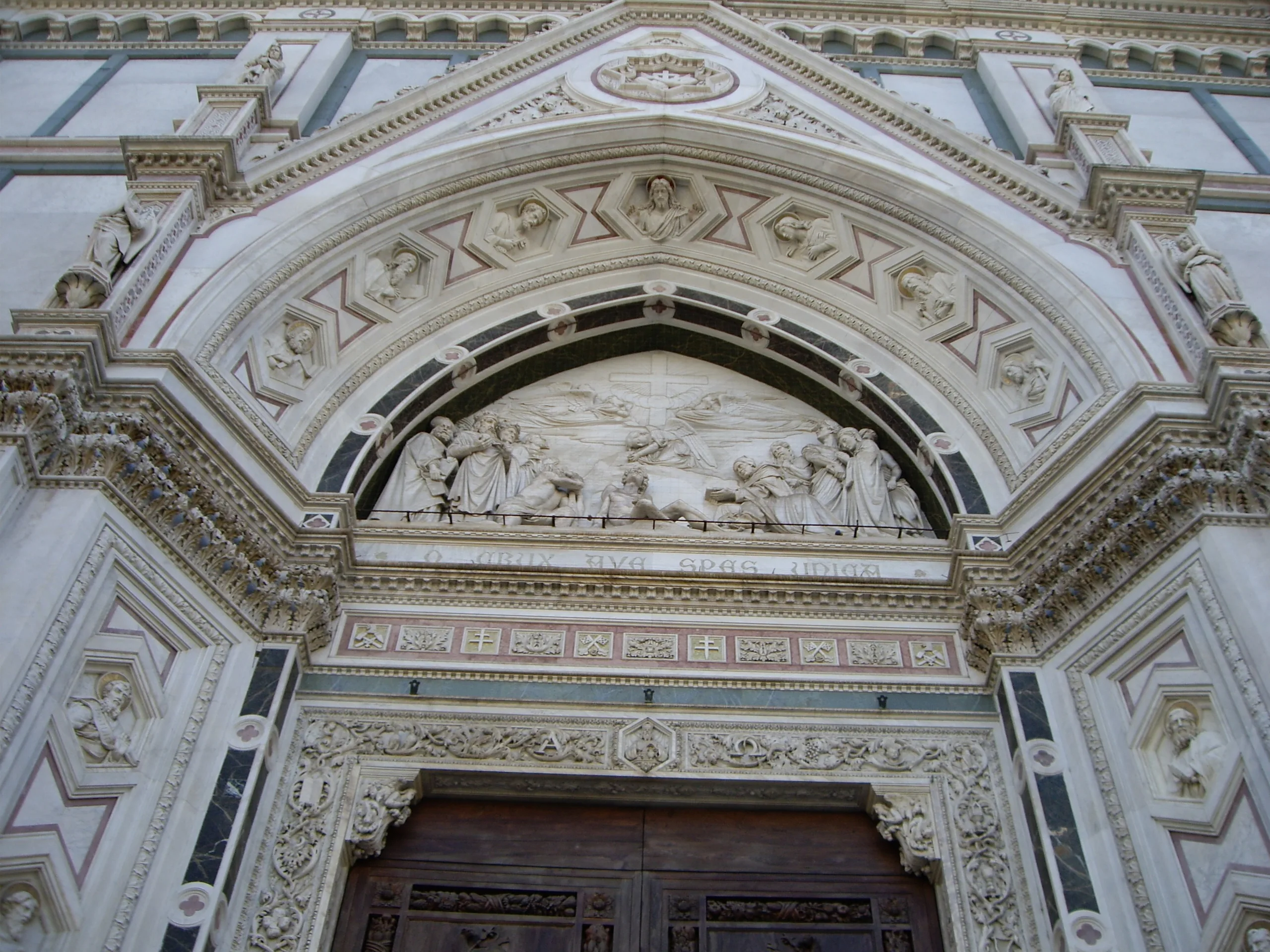 A carved stone portal and lunette inside Santa Croce