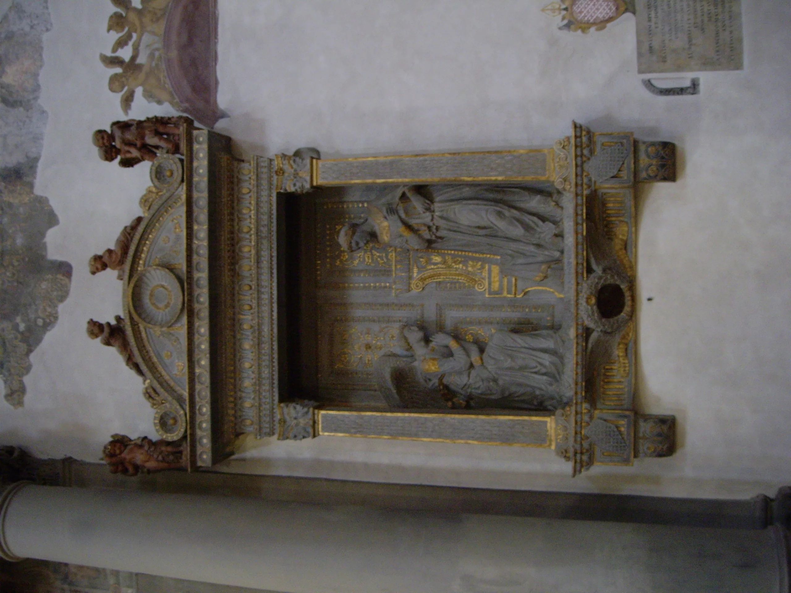 A carved marble wall tomb set into the aisle of Santa Croce