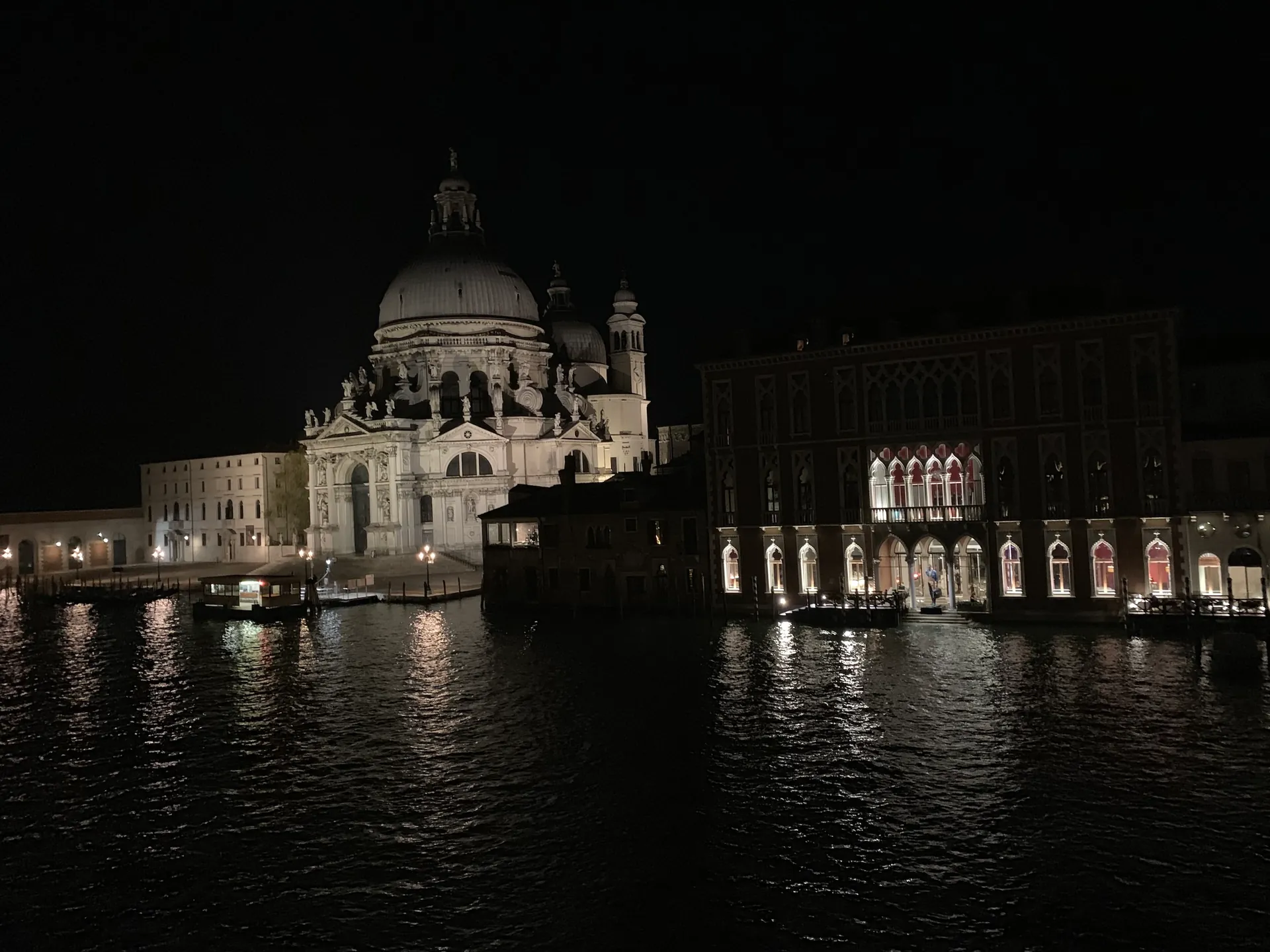 The floodlit dome of Santa Maria della Salute reflected in the Grand Canal at night