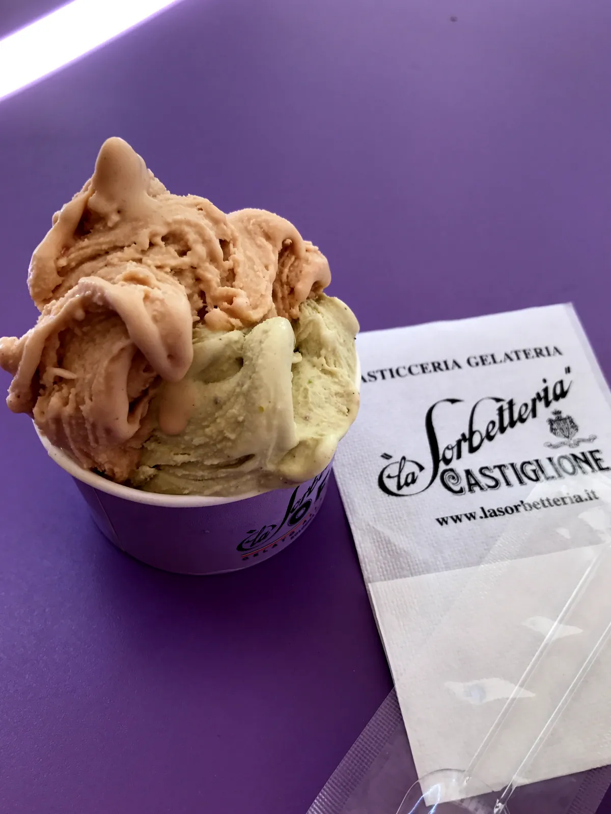 A purple cup of La Sorbetteria Castiglione with two scoops of gelato.