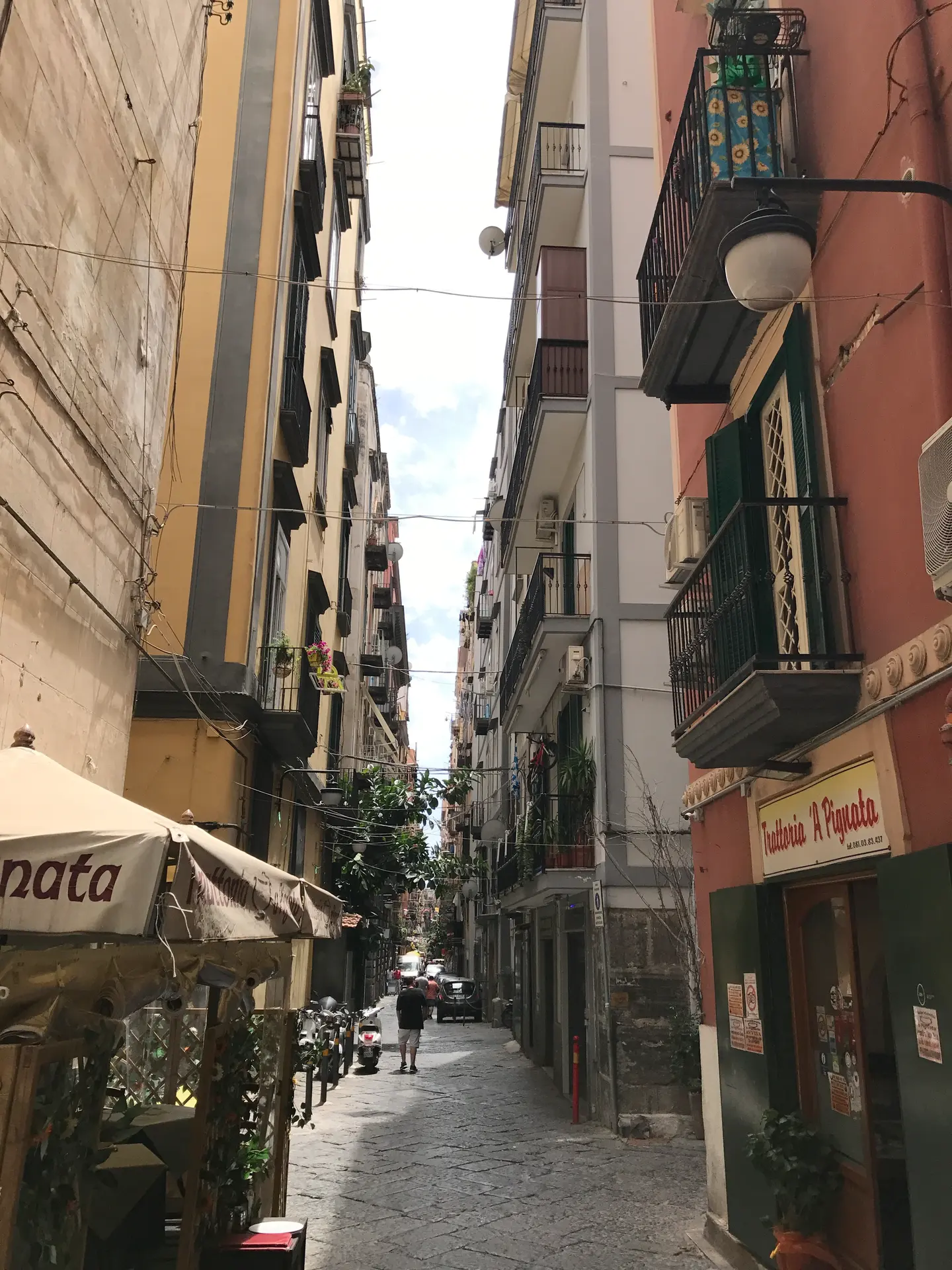 A narrow street with awnings and shutters in the Spanish Quarter of Naples