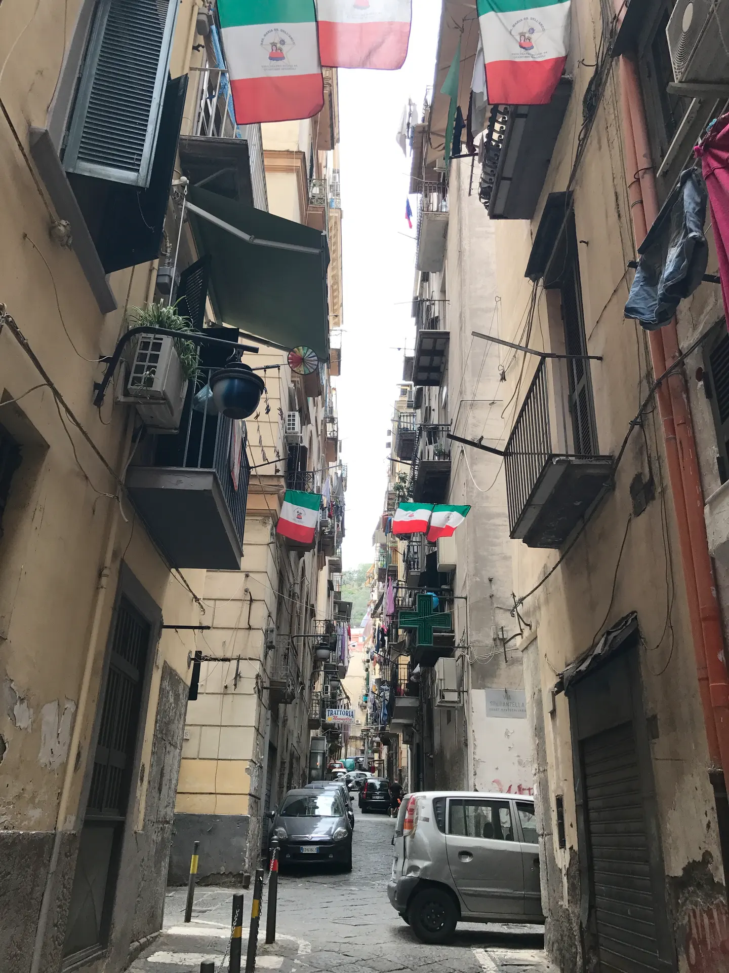 Italian flags and hanging laundry across a street in the Spanish Quarter, Naples