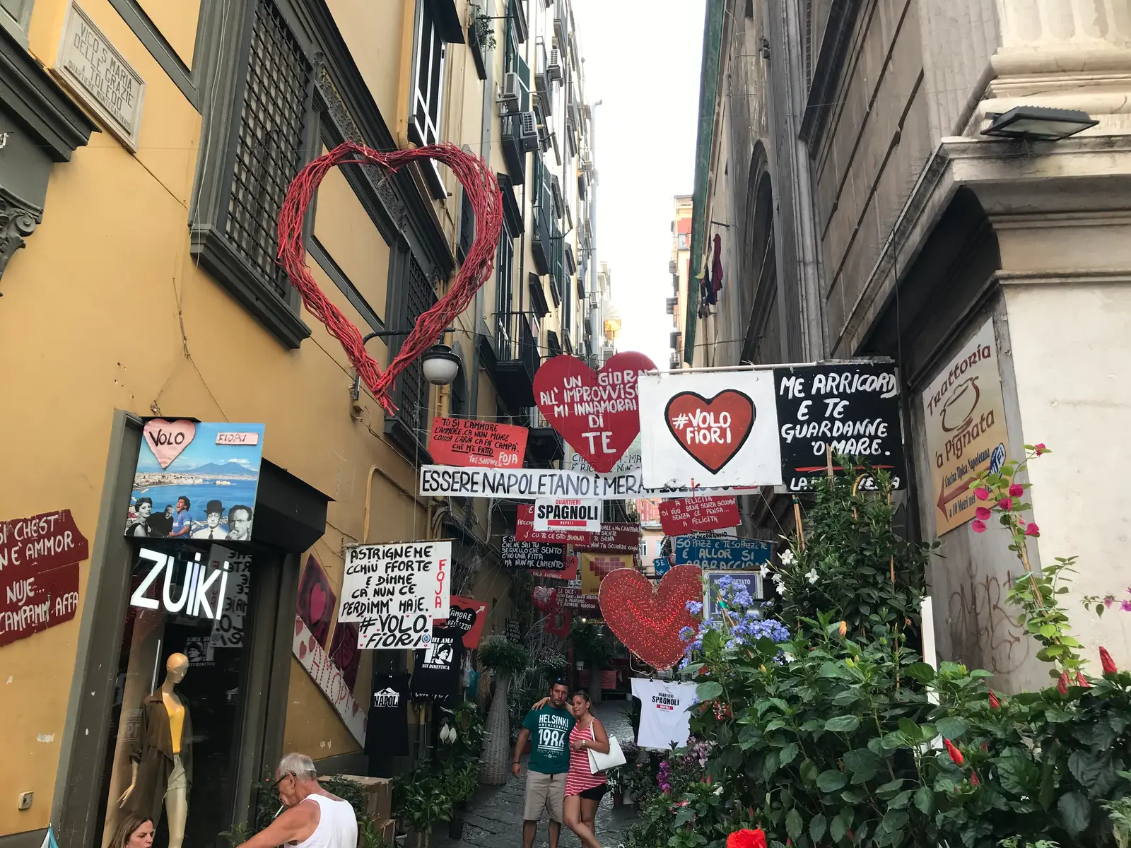 A street corner covered in signs and red hearts in the Spanish Quarter, Naples